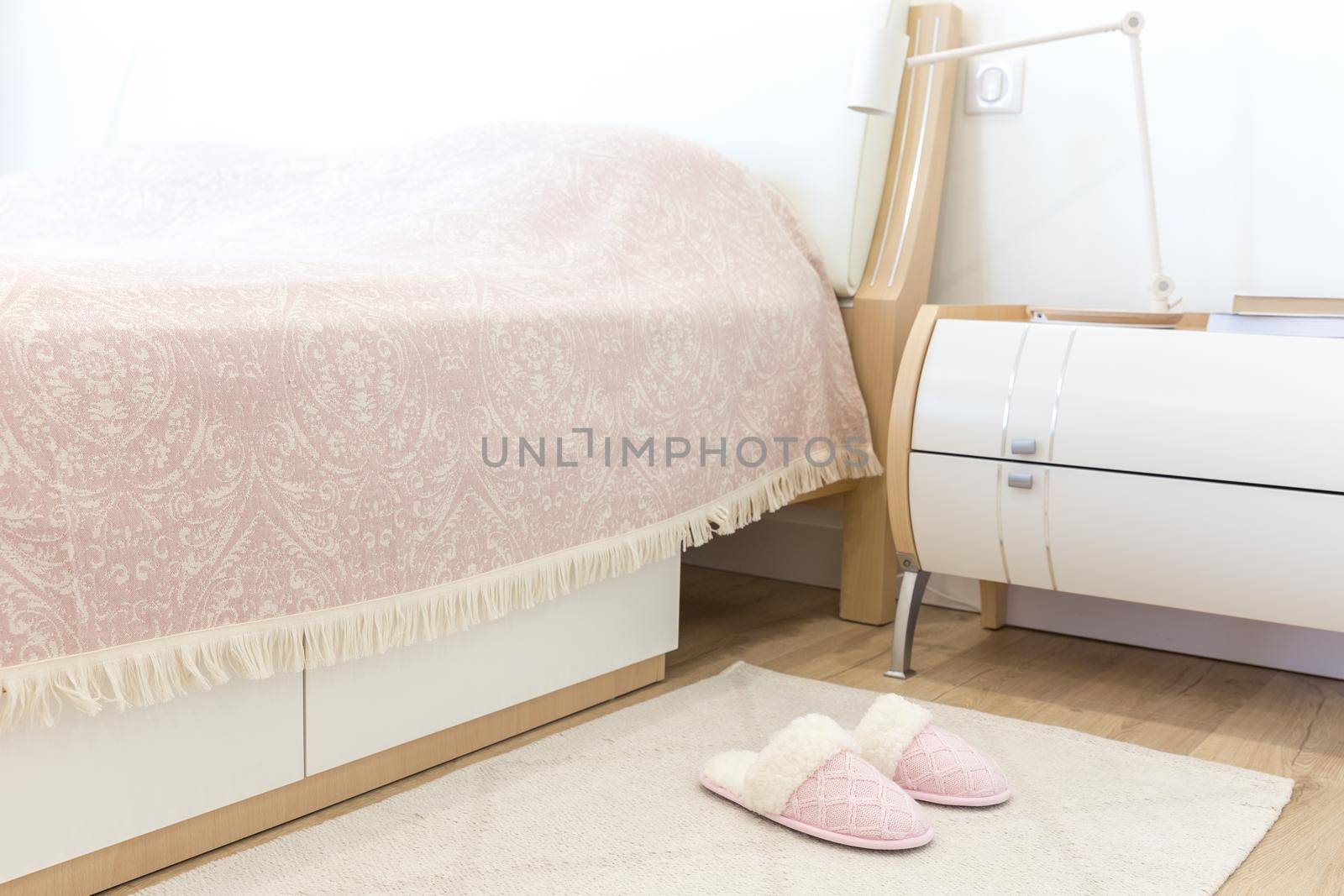 Bedroom in modern style with pink cozy soft slippers on floor