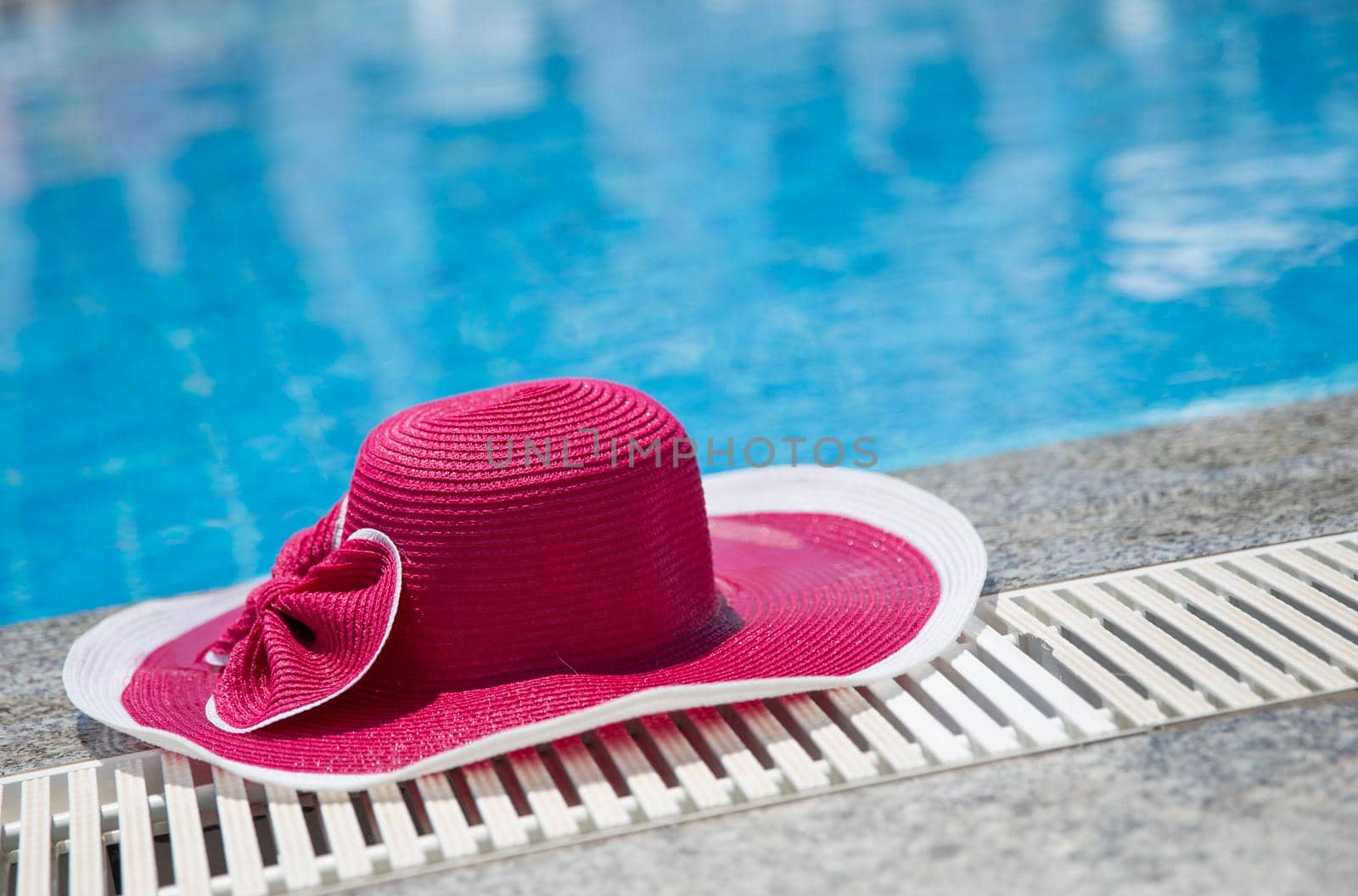 Nice pink hat with a bow near the pool