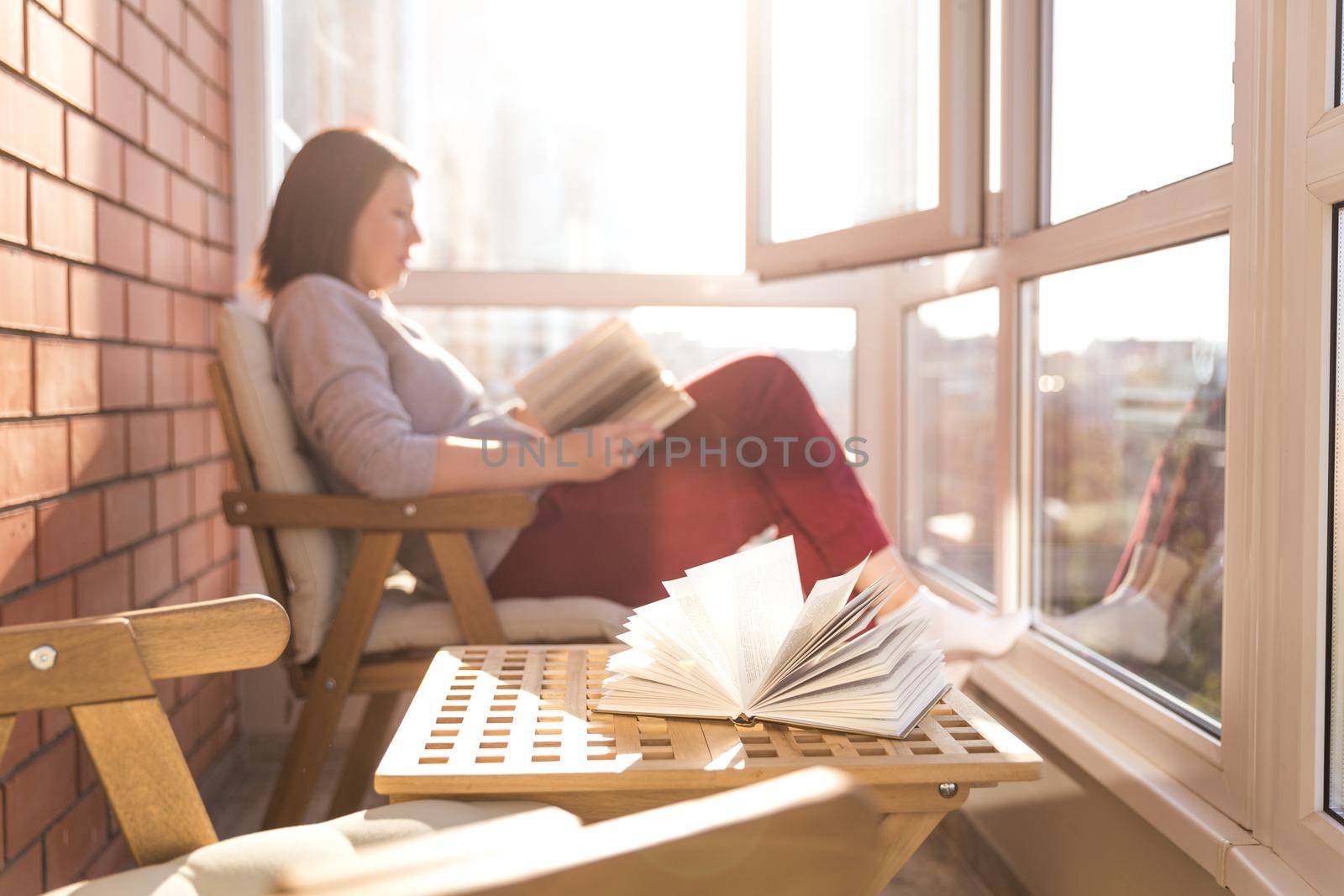relaxed woman reading on balcony on a warm sunny day