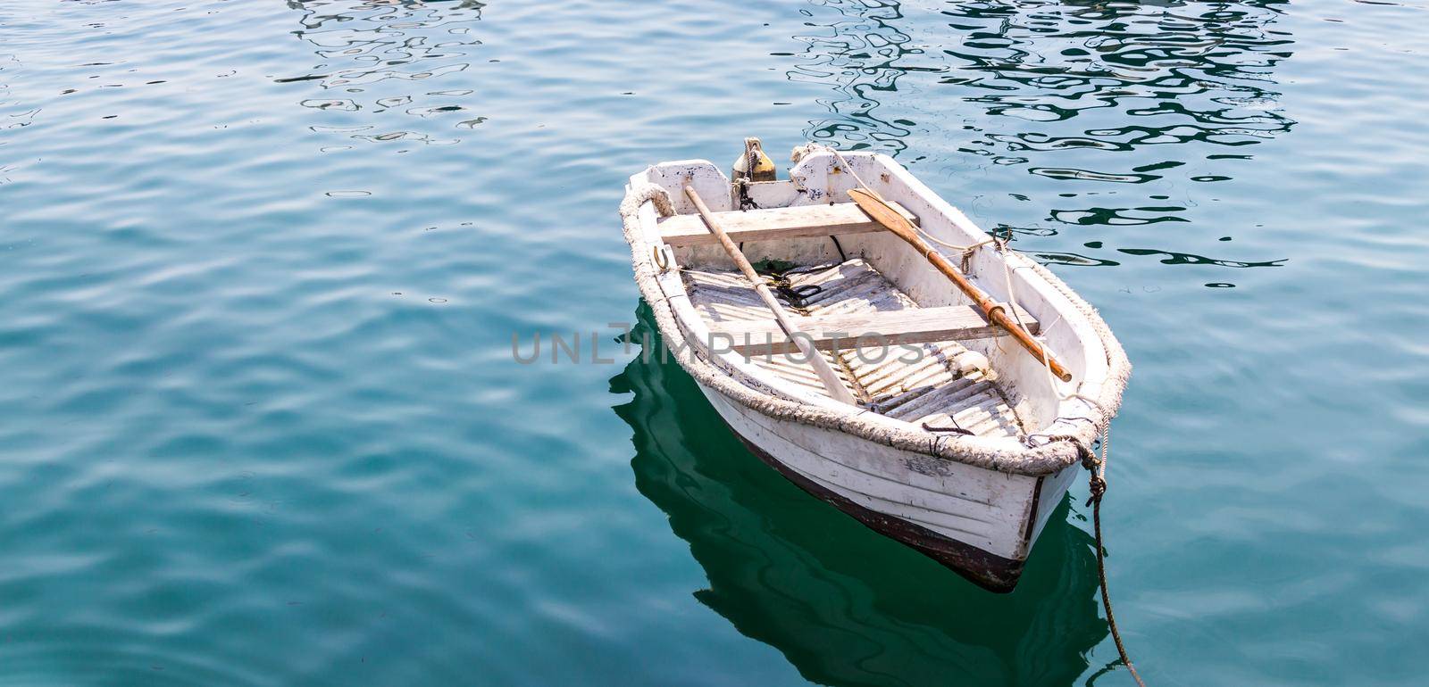white wooden boat on blue calm water in a lake