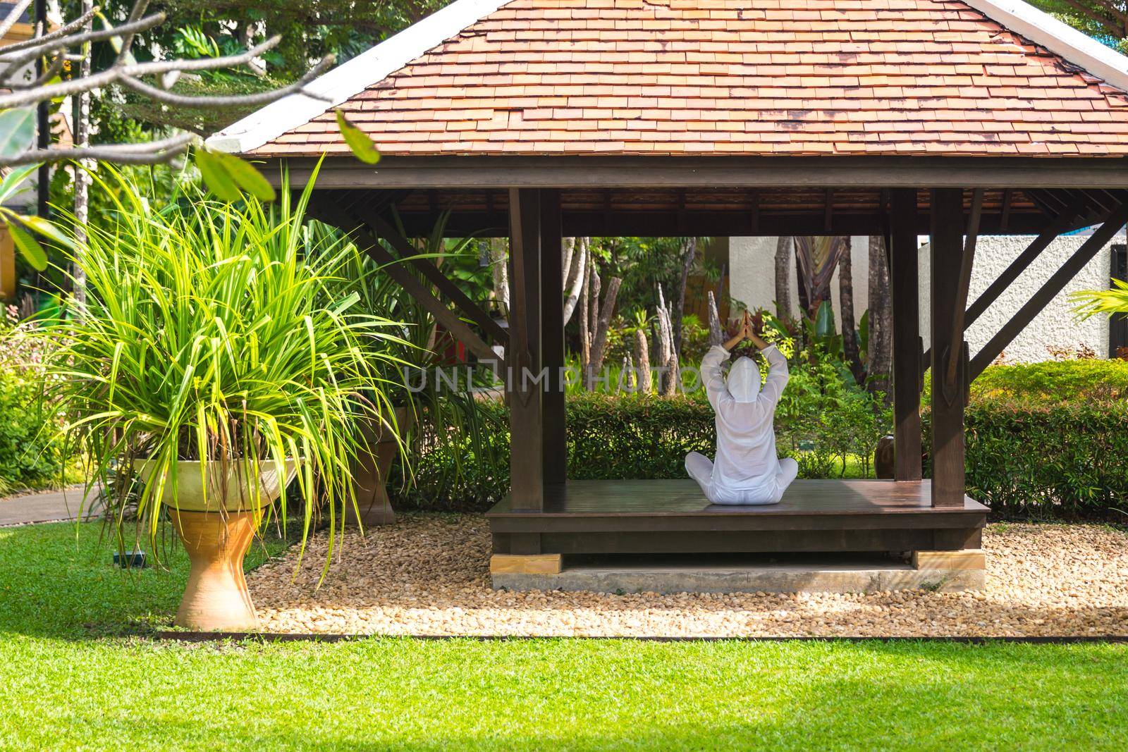 Woman in gazebo practicing yoga in Thailand in Asia by Mariakray