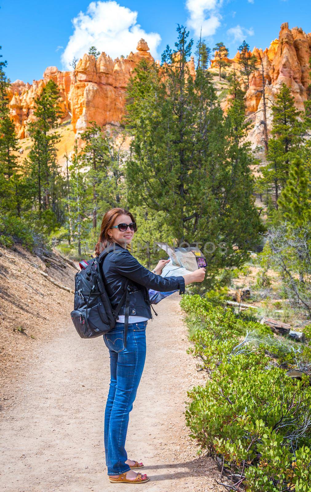 Girl searching right direction on map in Bryce Canyon, USA