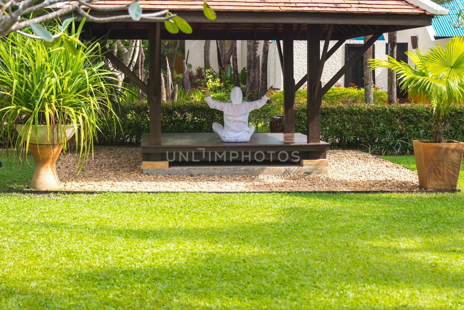 Woman in gazebo practicing yoga in Thailand in Asia by Mariakray