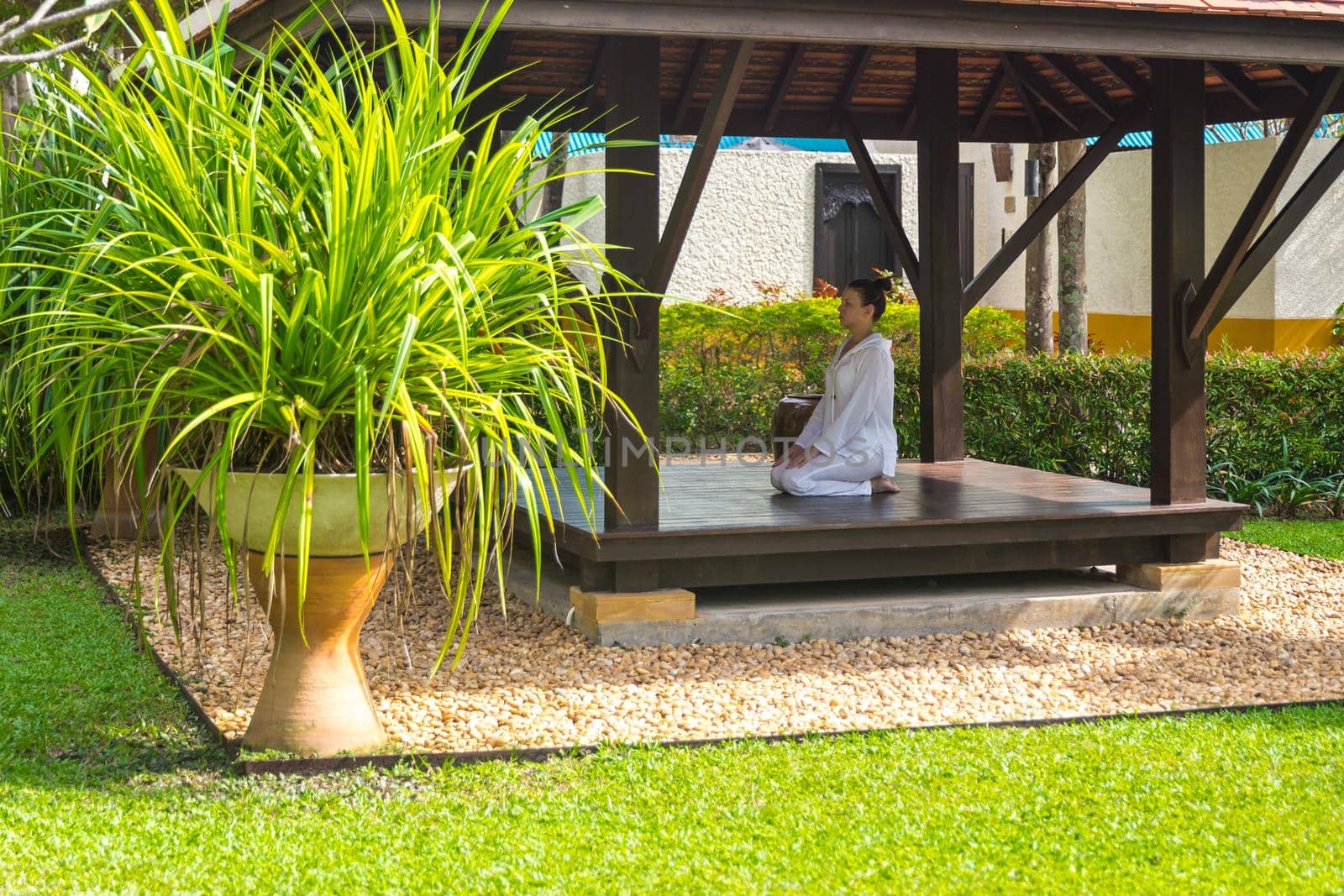 Woman in gazebo practicing yoga in Thailand