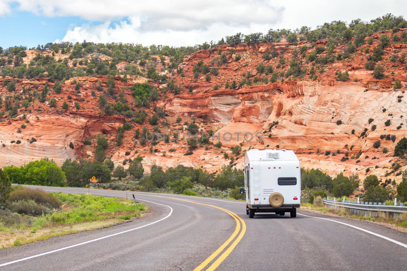 White Colour Motorhome Car Goes On Road On Background Of Mountains