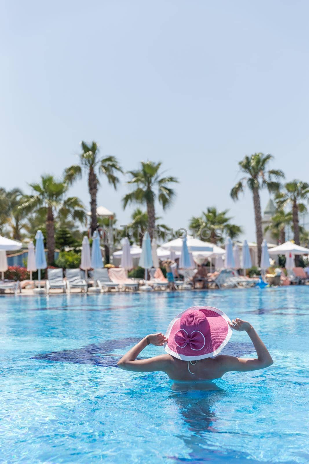 Woman in pink hat standing in a pool