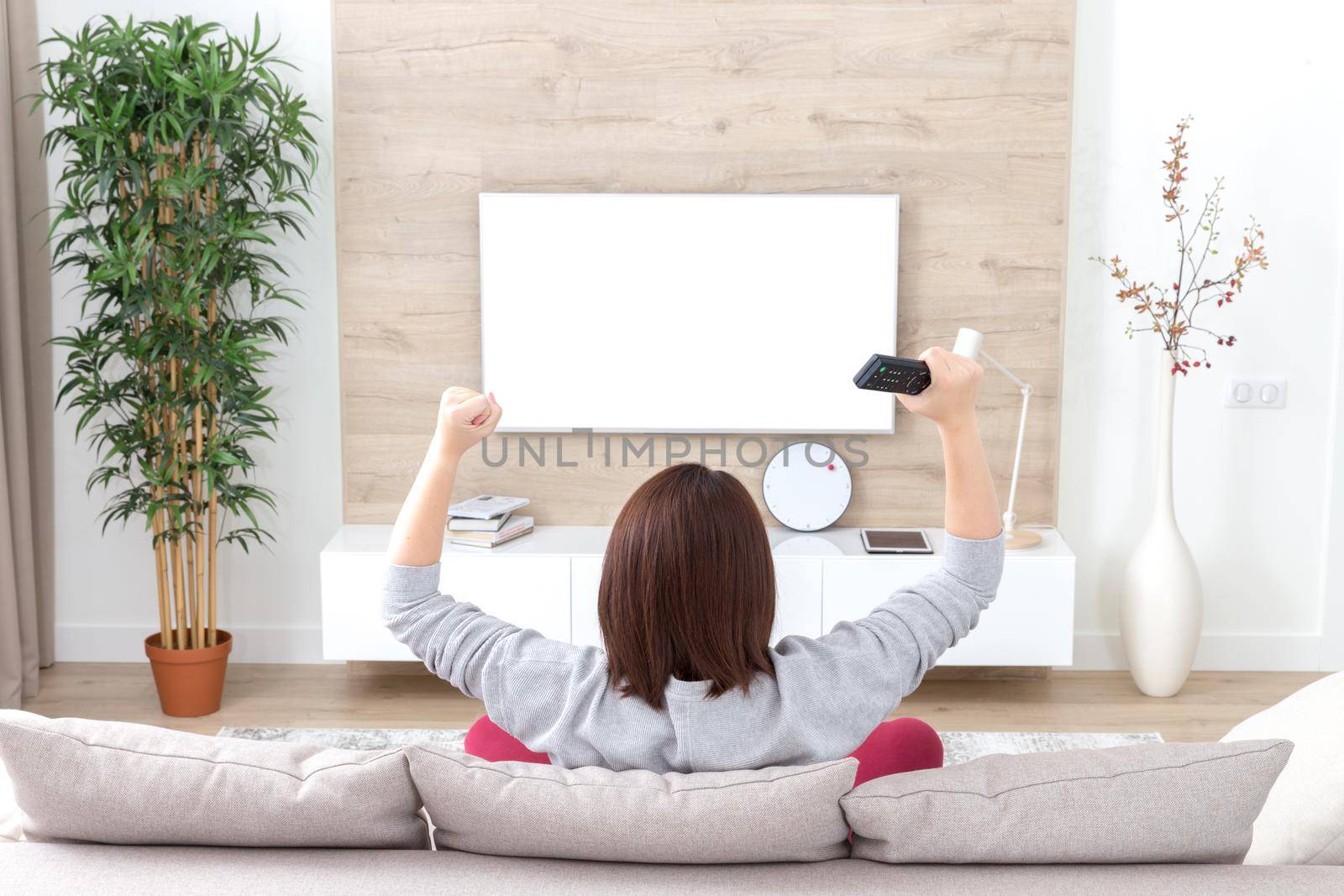 young happy woman watching alone excited television football sport match or TV contest