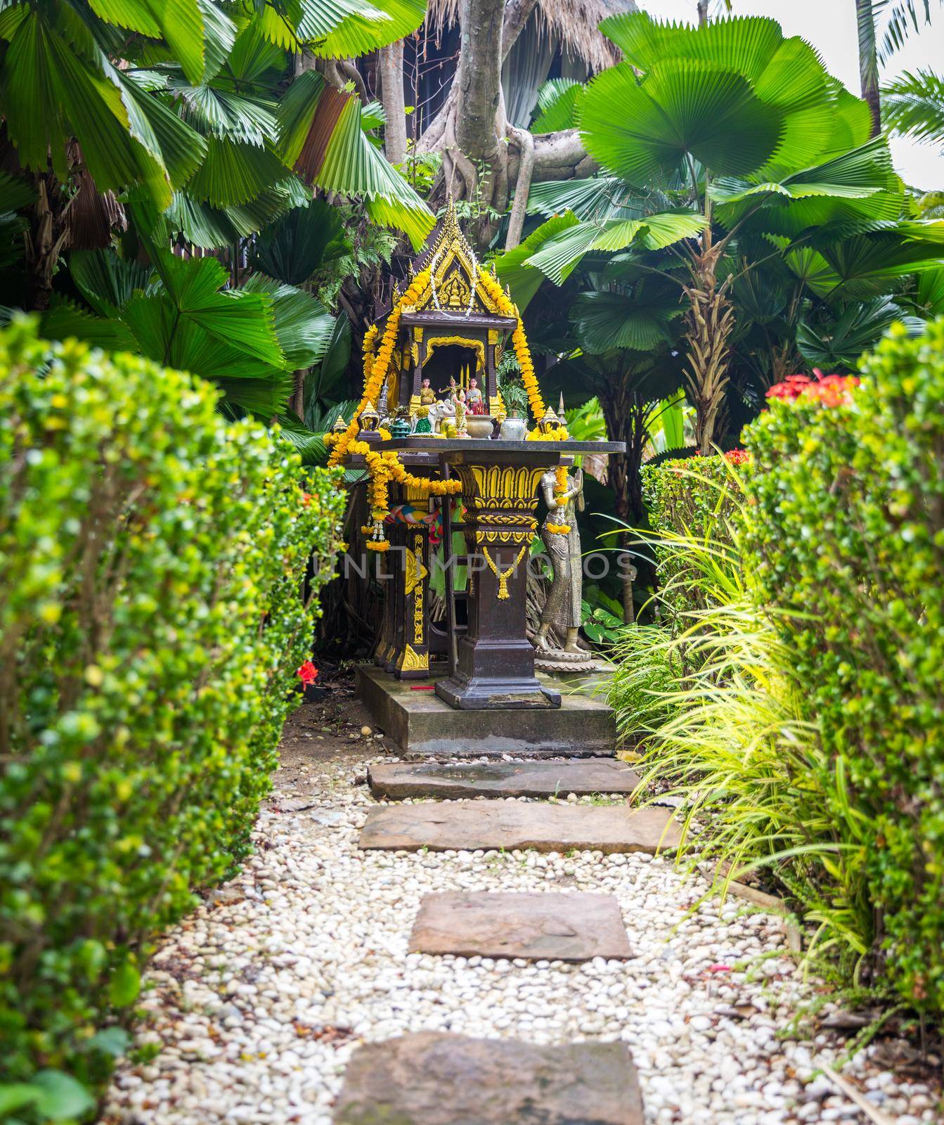 Traditional Thai spirit house with colorful garlands in Thailand