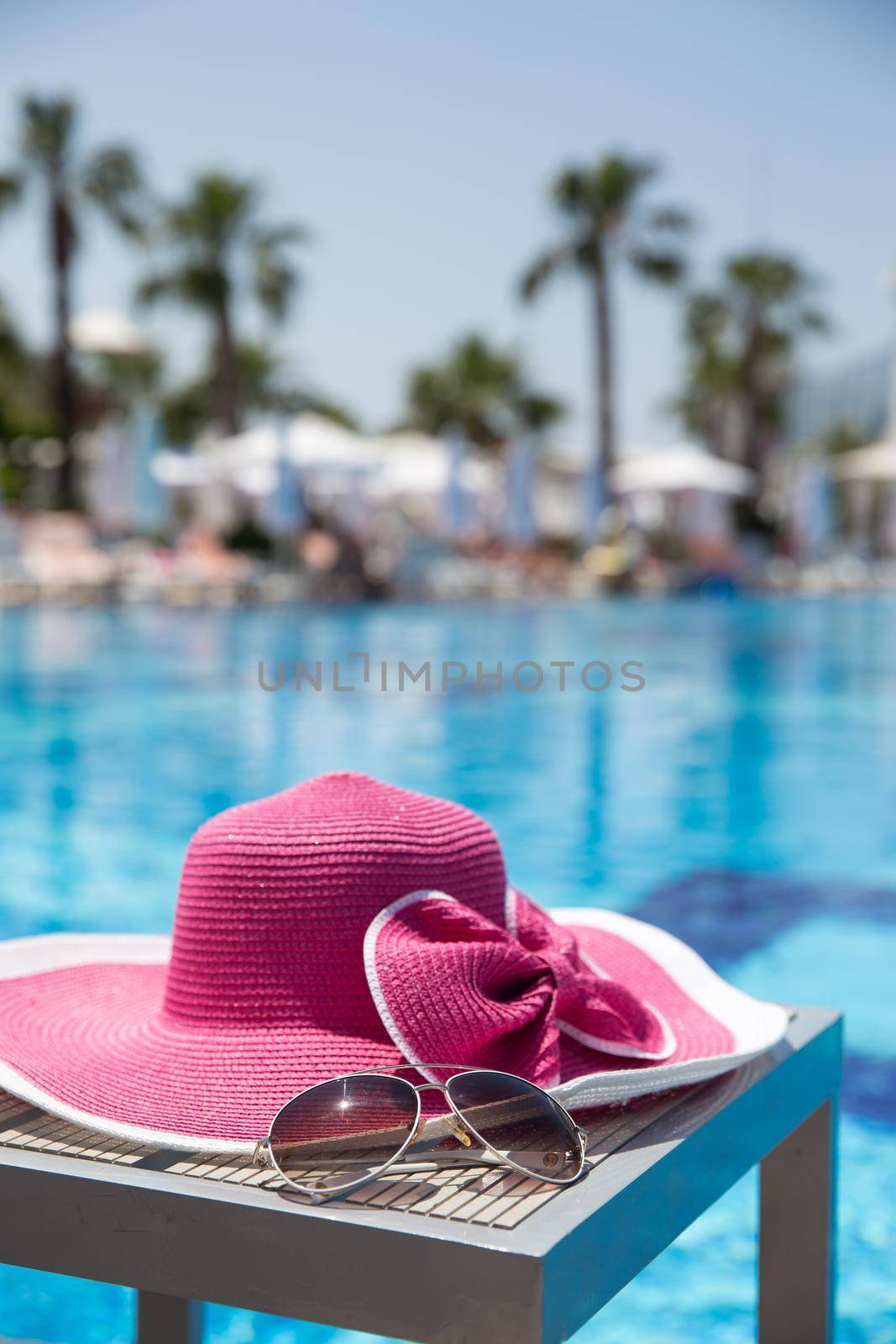 Nice pink hat with a bow near the pool