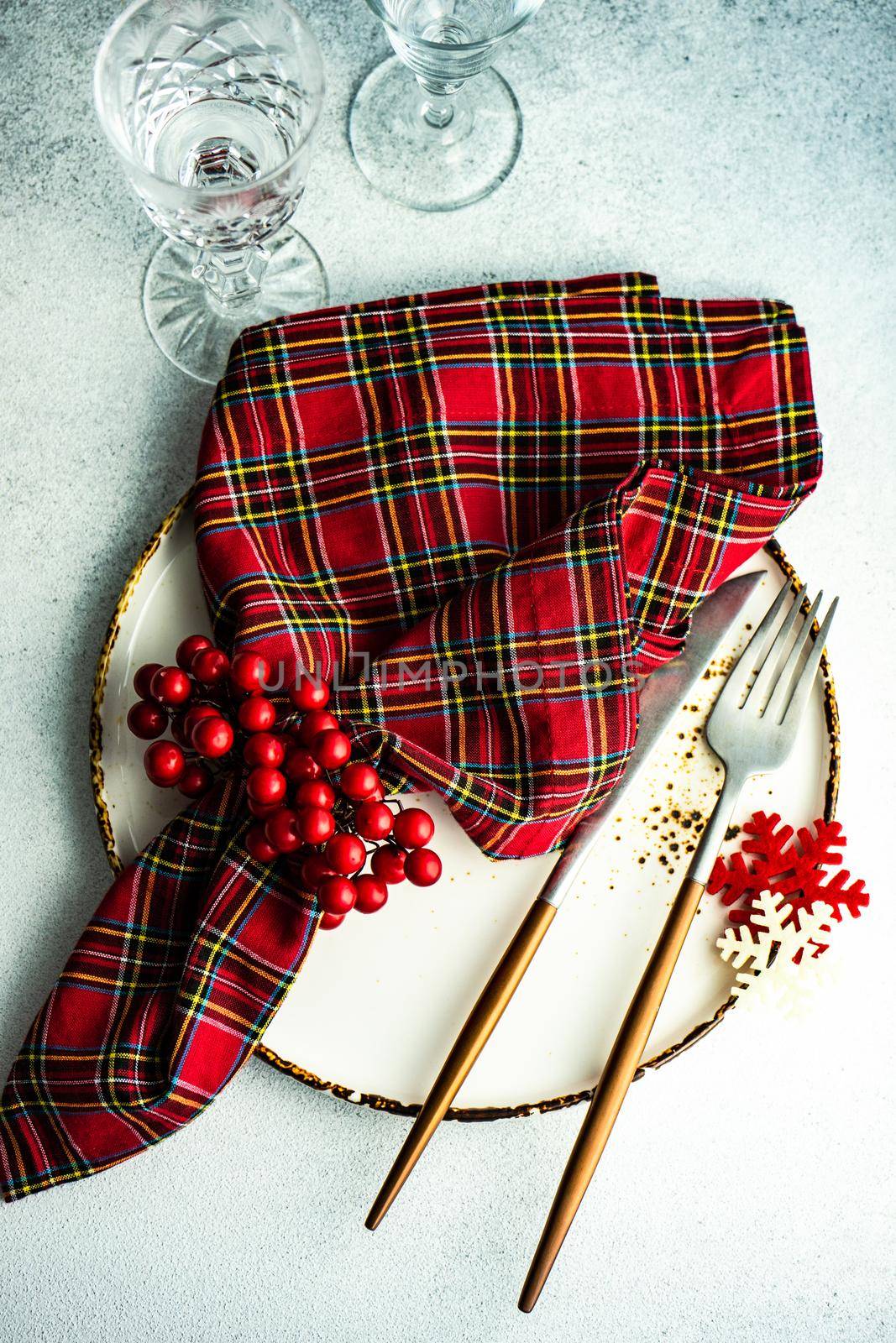 Festive place setting for Christmas dinner on concrete background