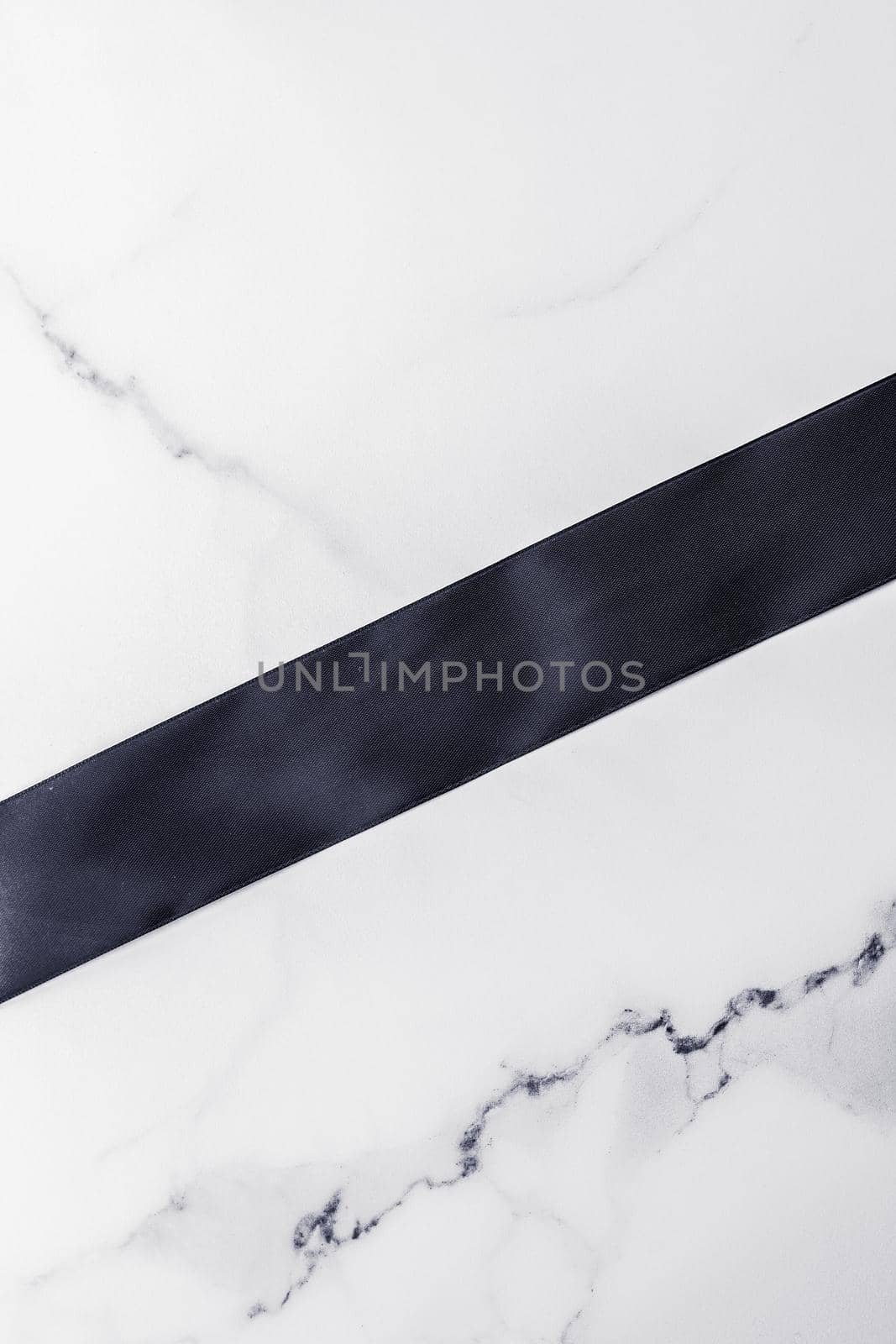 Holiday gift, decoration and sale promotion concept - Black silk ribbon and bow on marble background, flatlay