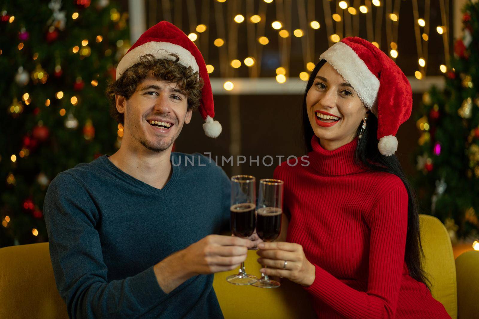 Couple lover man and woman smile to camera with hold glass of  champagne or wine to celebrate Christmas festival together at night.