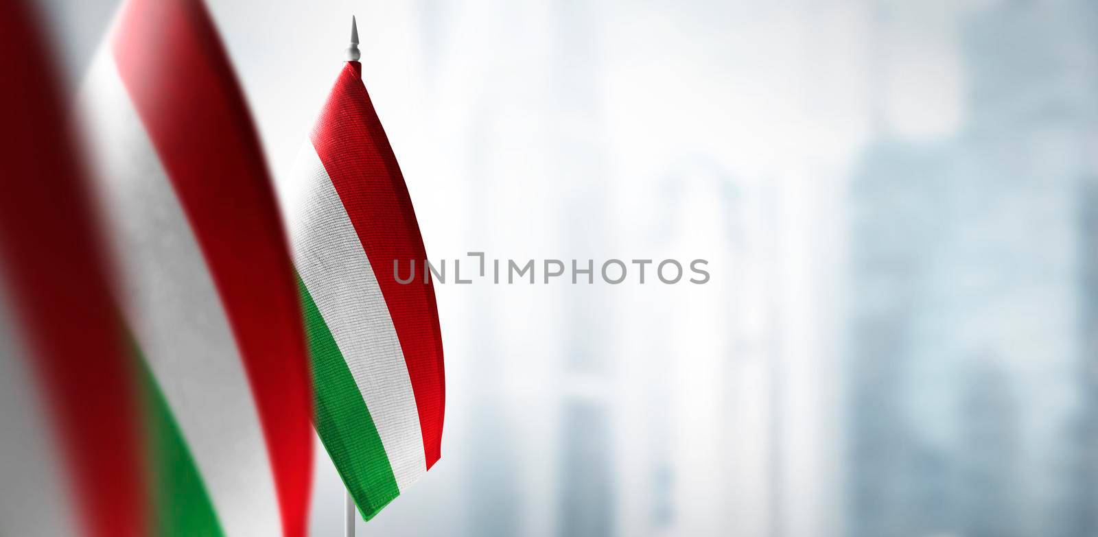 Small flags of Bulgaria on the background of an urban abstract blurred background.