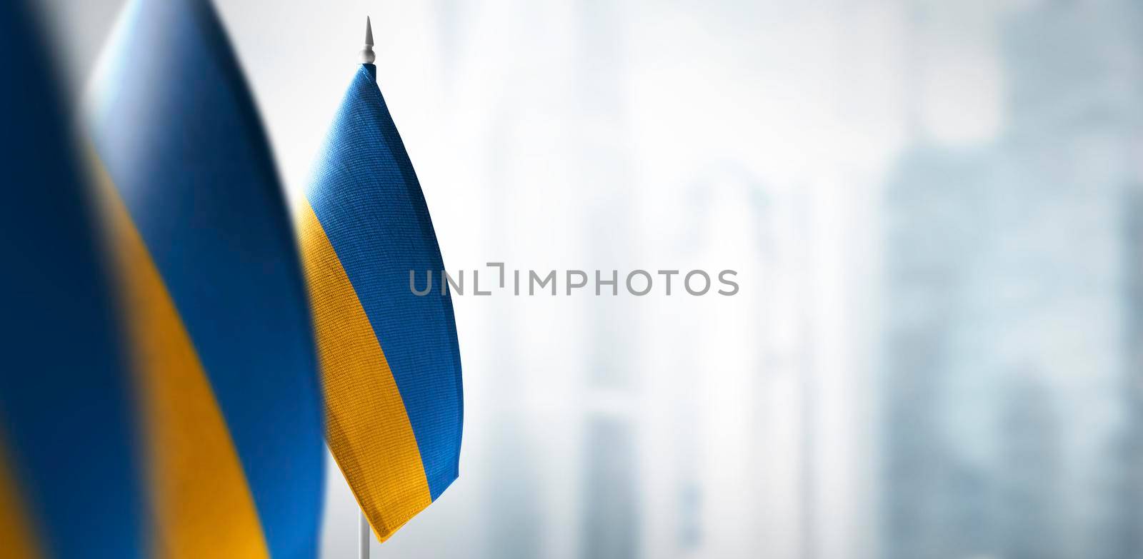 Small flags of Ukraine on a blurry background of the city by butenkow