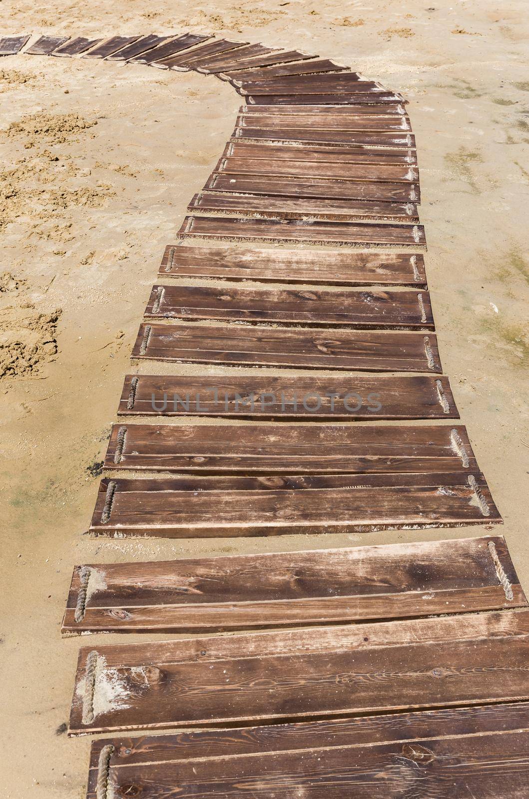 Wooden beach boardwalk, path with sand with copy space