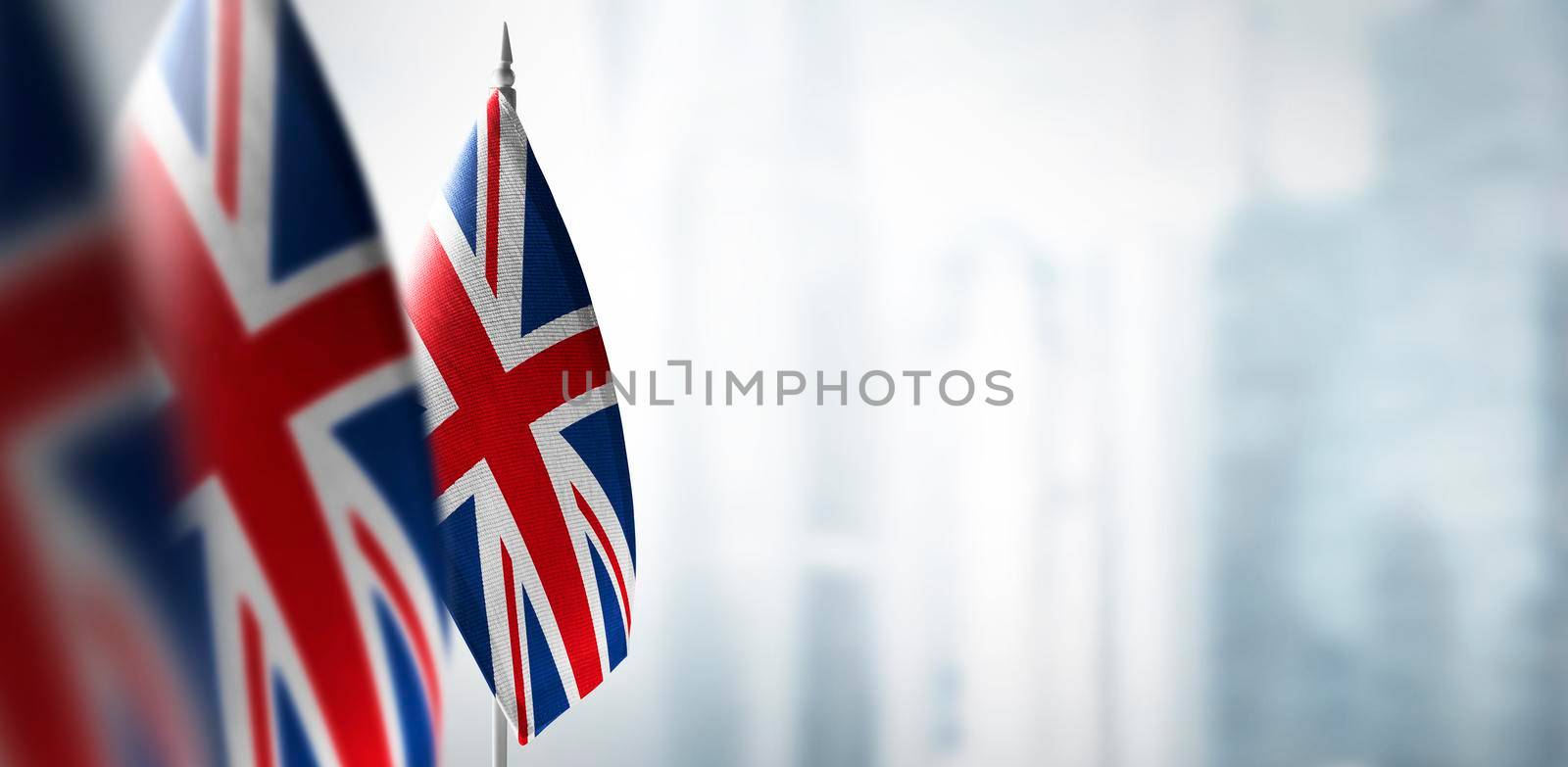 Small flags of United Kingdom on a blurry background of the city.