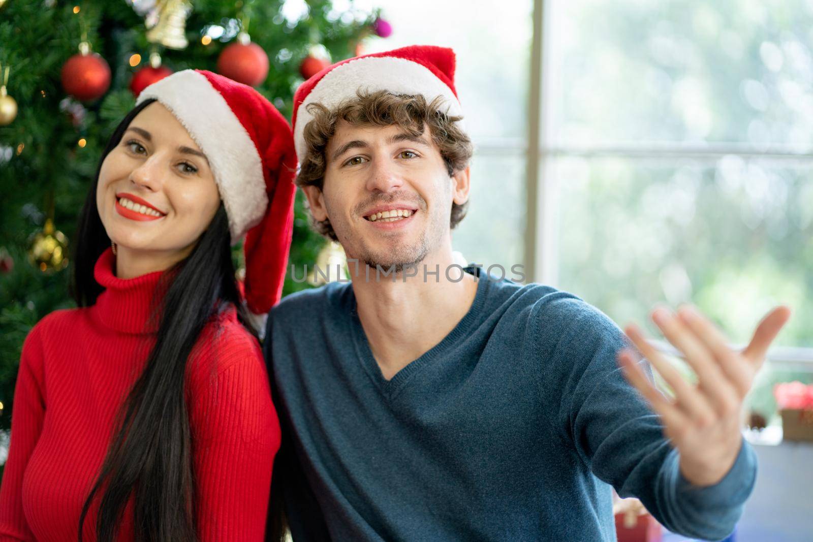 Couple man and woman smile and look at camera during Christmas festival.