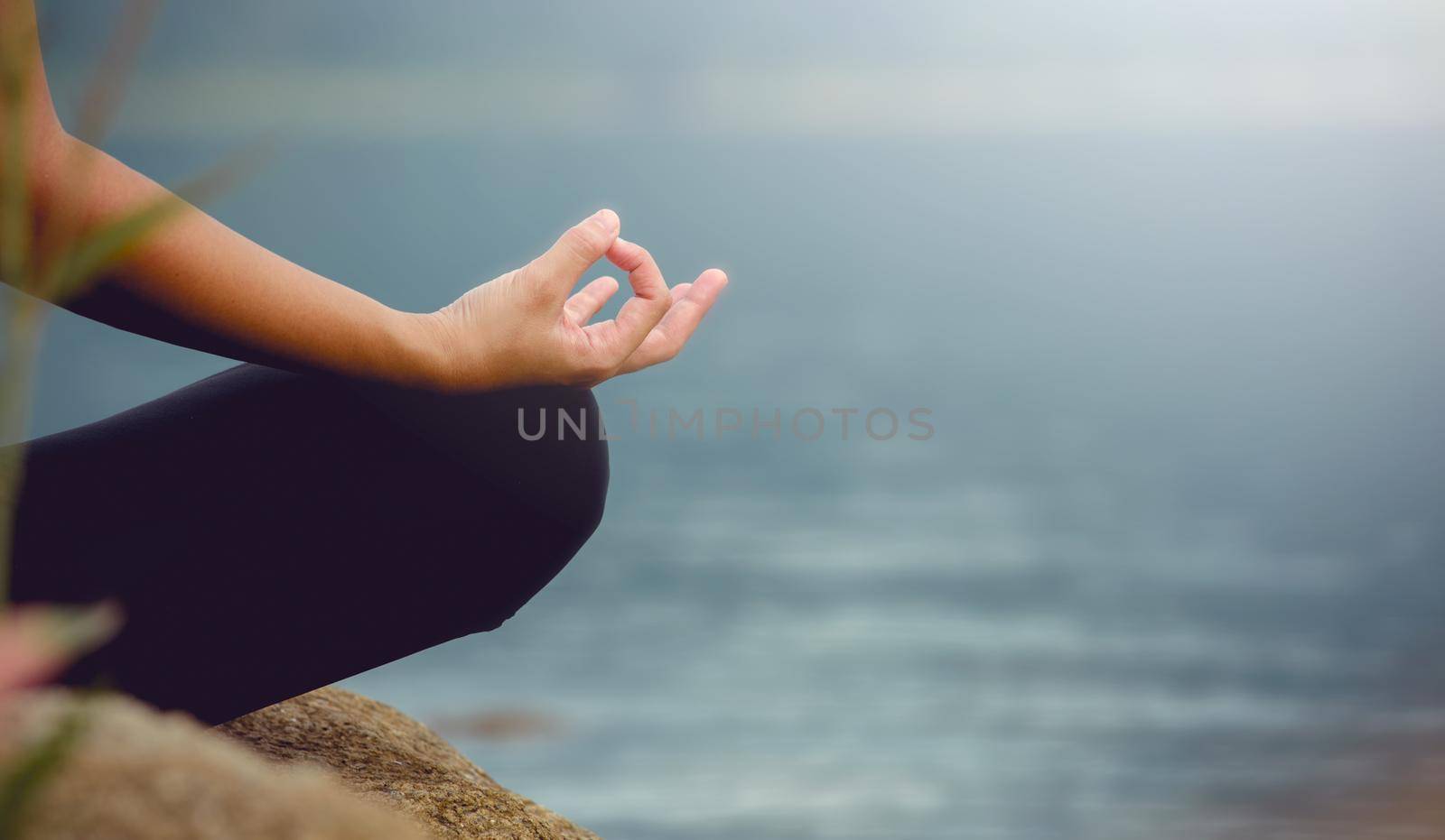Close up of a woman hands doing yoga exercise in the river background.