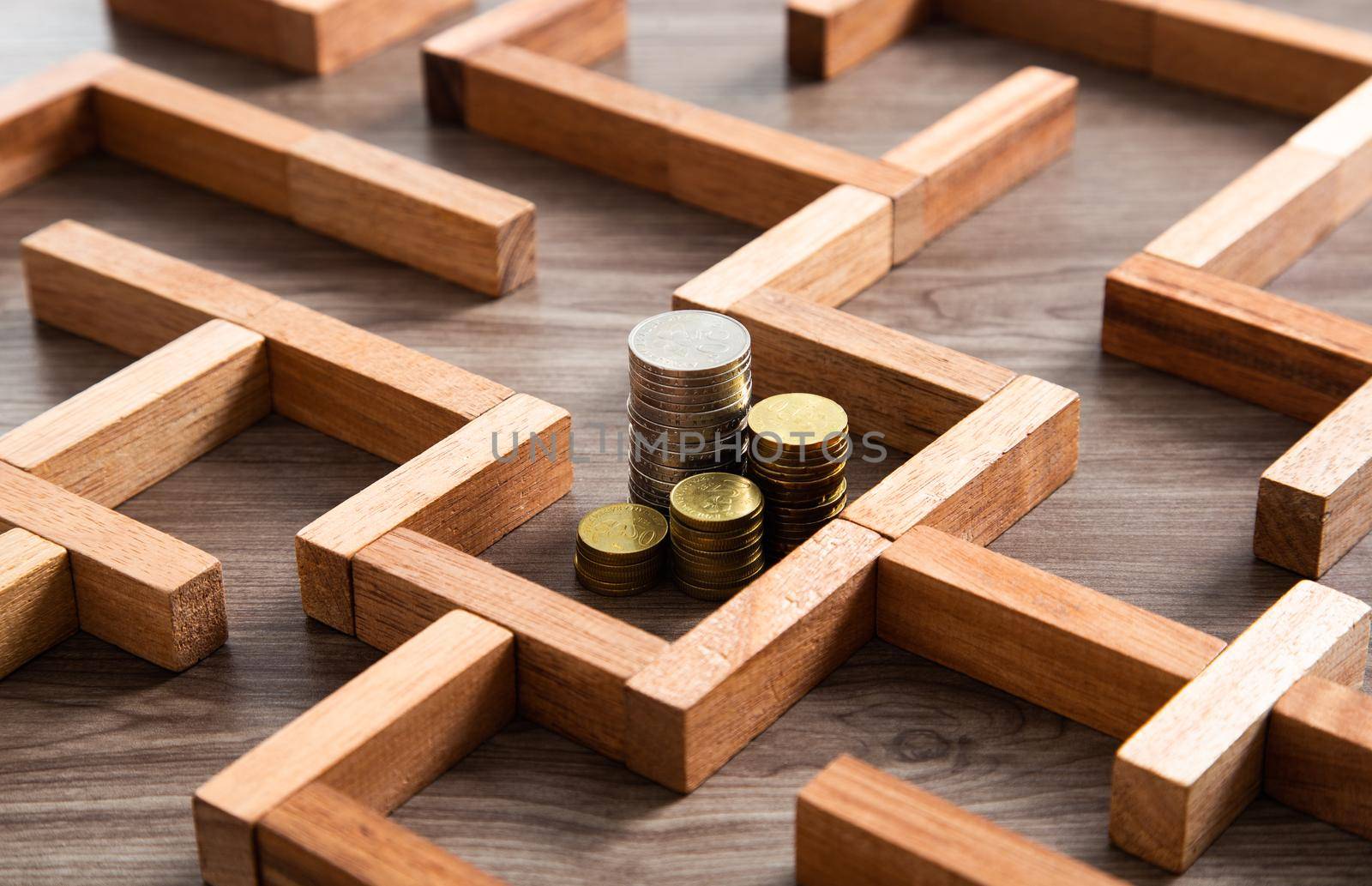 Group of coins heaps in the maze game built by wood blocks, find a way to money resource concept by tehcheesiong