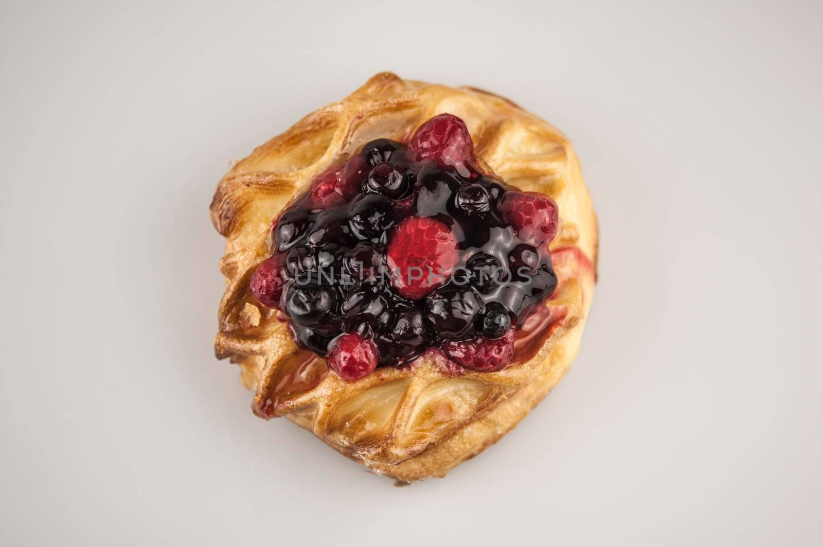 Delicious pastries with berries on a white background