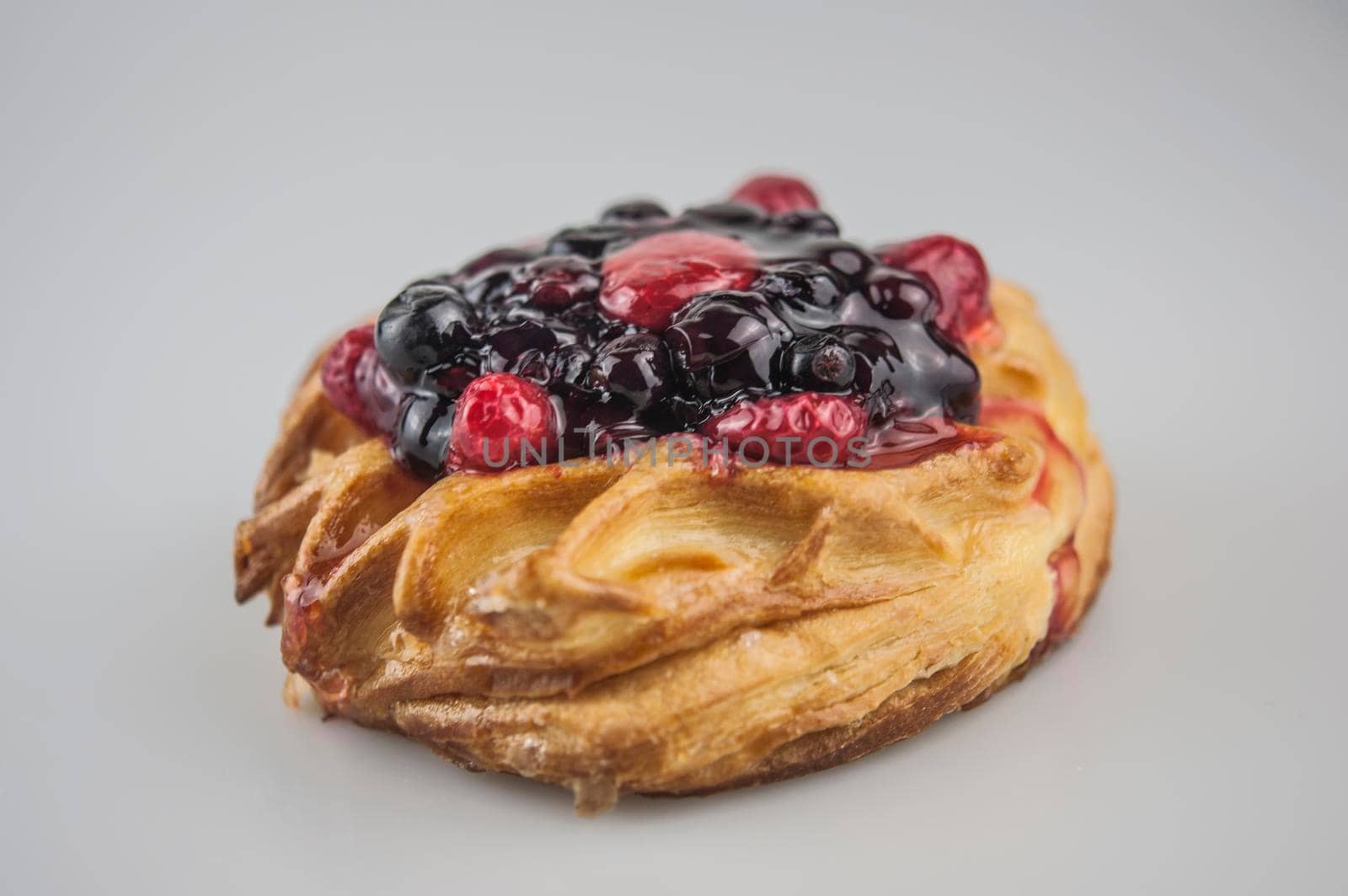Delicious pastries with berries on a white background