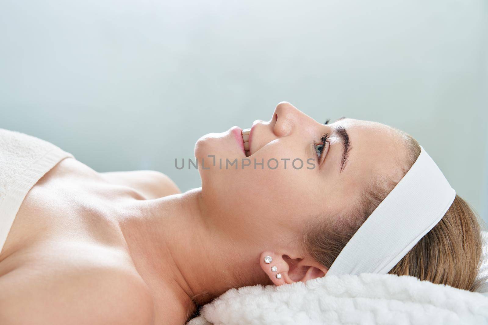 Closeup of relaxed young woman laying on table in a spa center. Relaxing massage and body care procedure. Wellness health and beauty concept