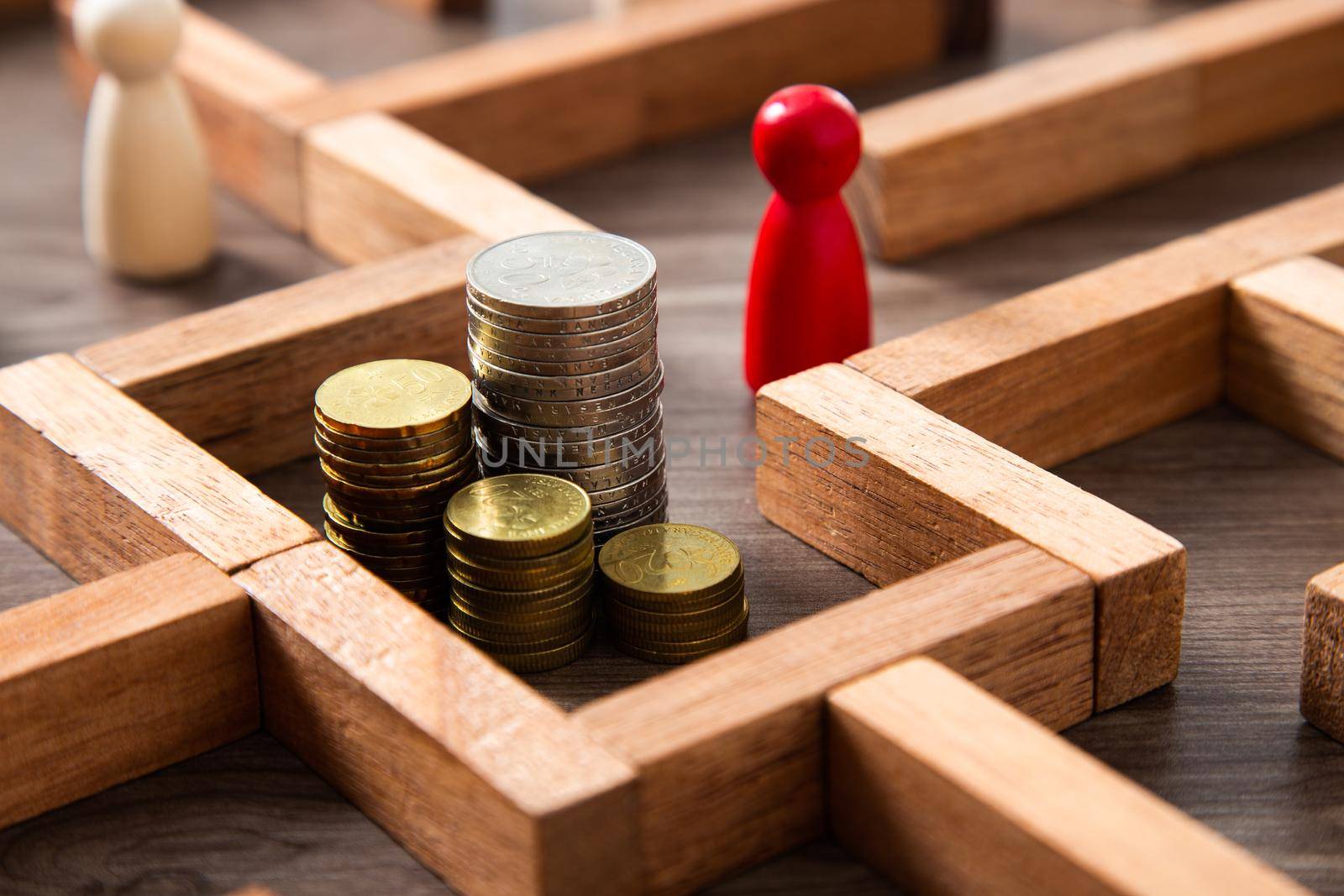 Group of coins heaps in the maze game built by wood blocks, find a way to money resource concept by tehcheesiong