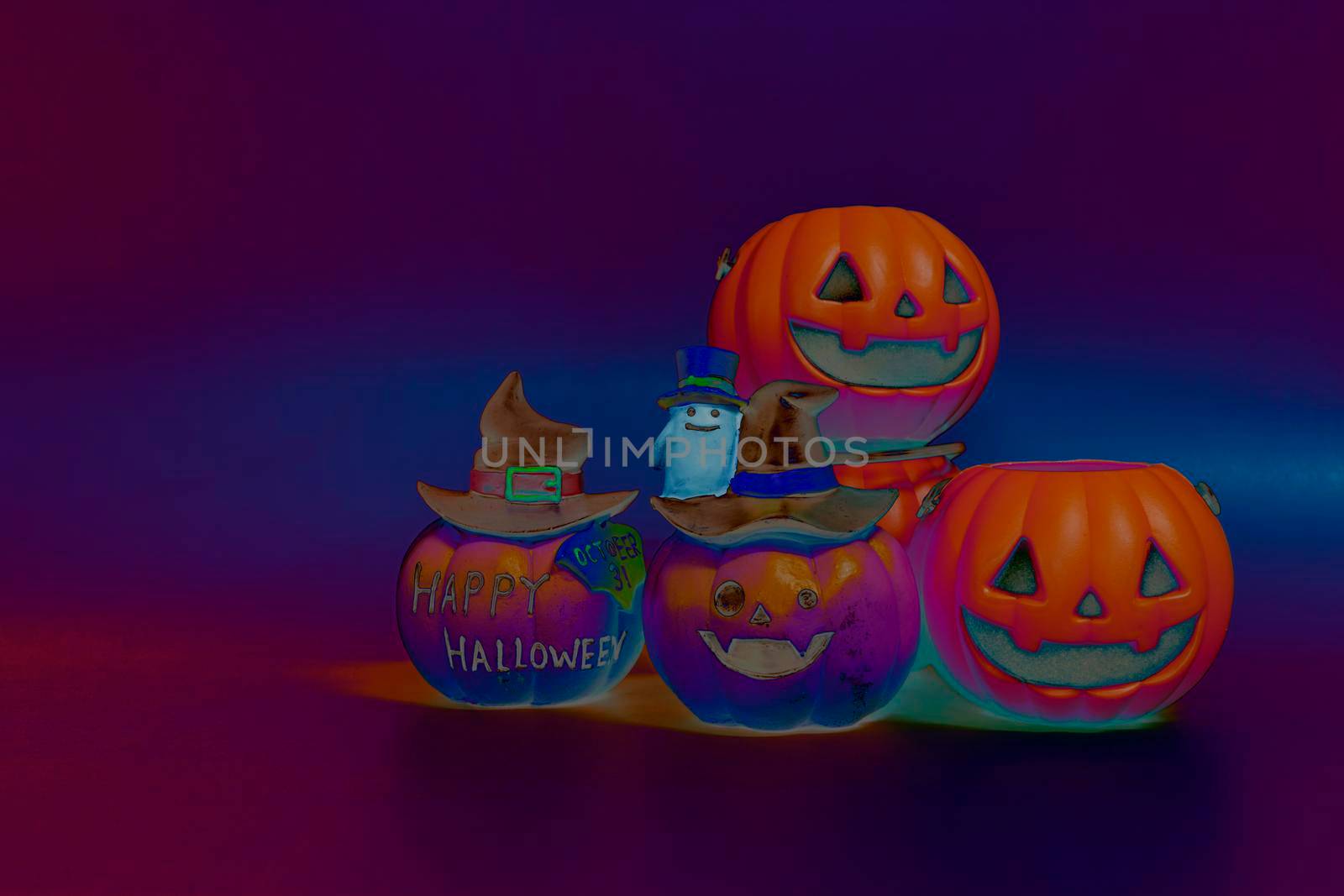 Jack o lantern pumpkin on a colorful dark background. Halloween concept backdrop