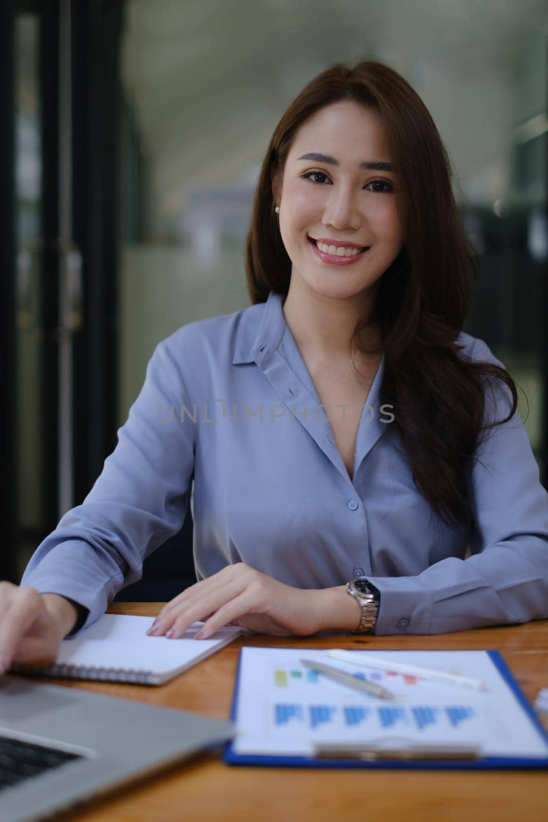 Photo of gorgeous secretary working at office. she sitting at the wooden desk. by itchaznong