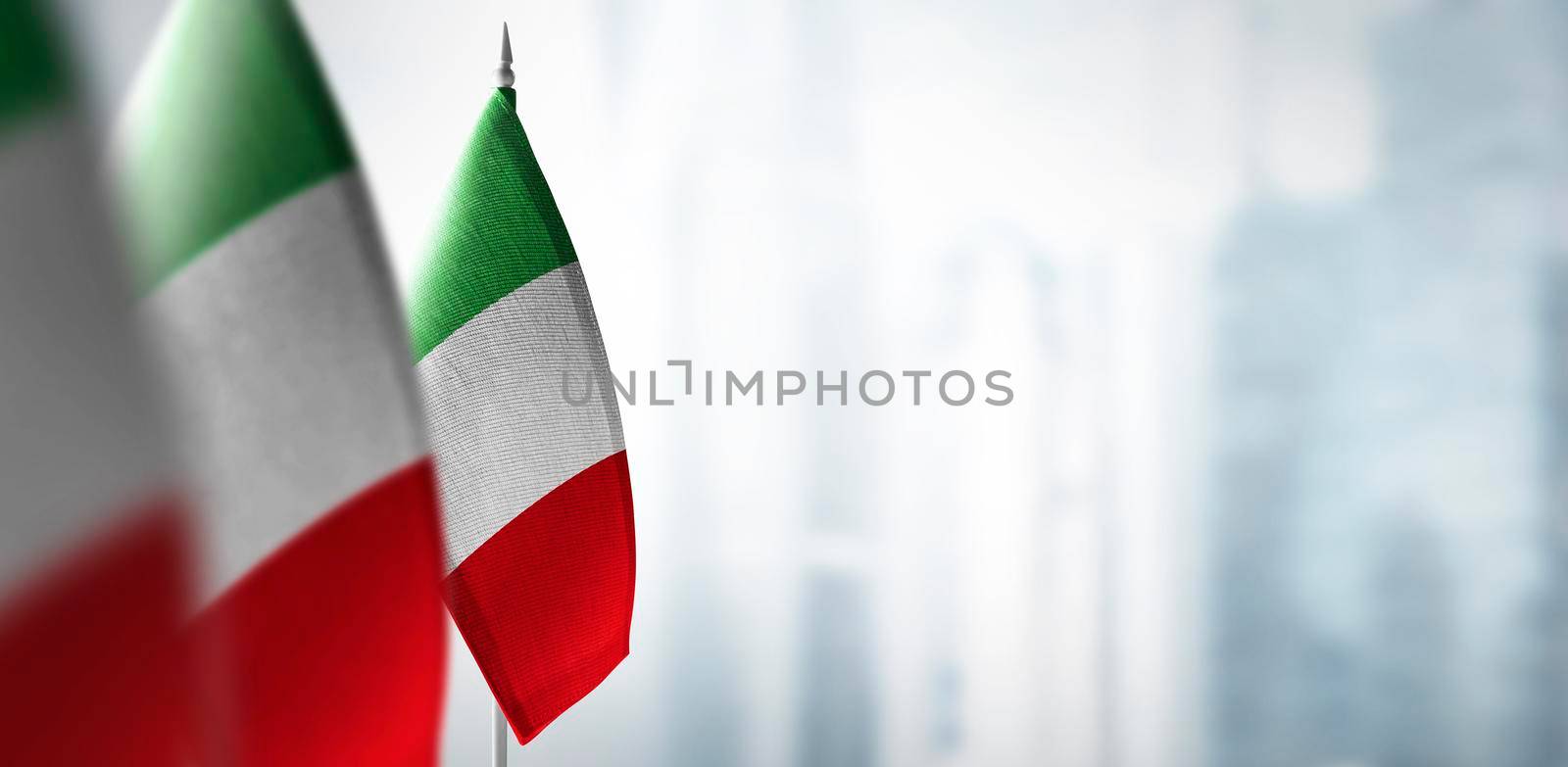 Small flags of Italy on a blurry background of the city by butenkow