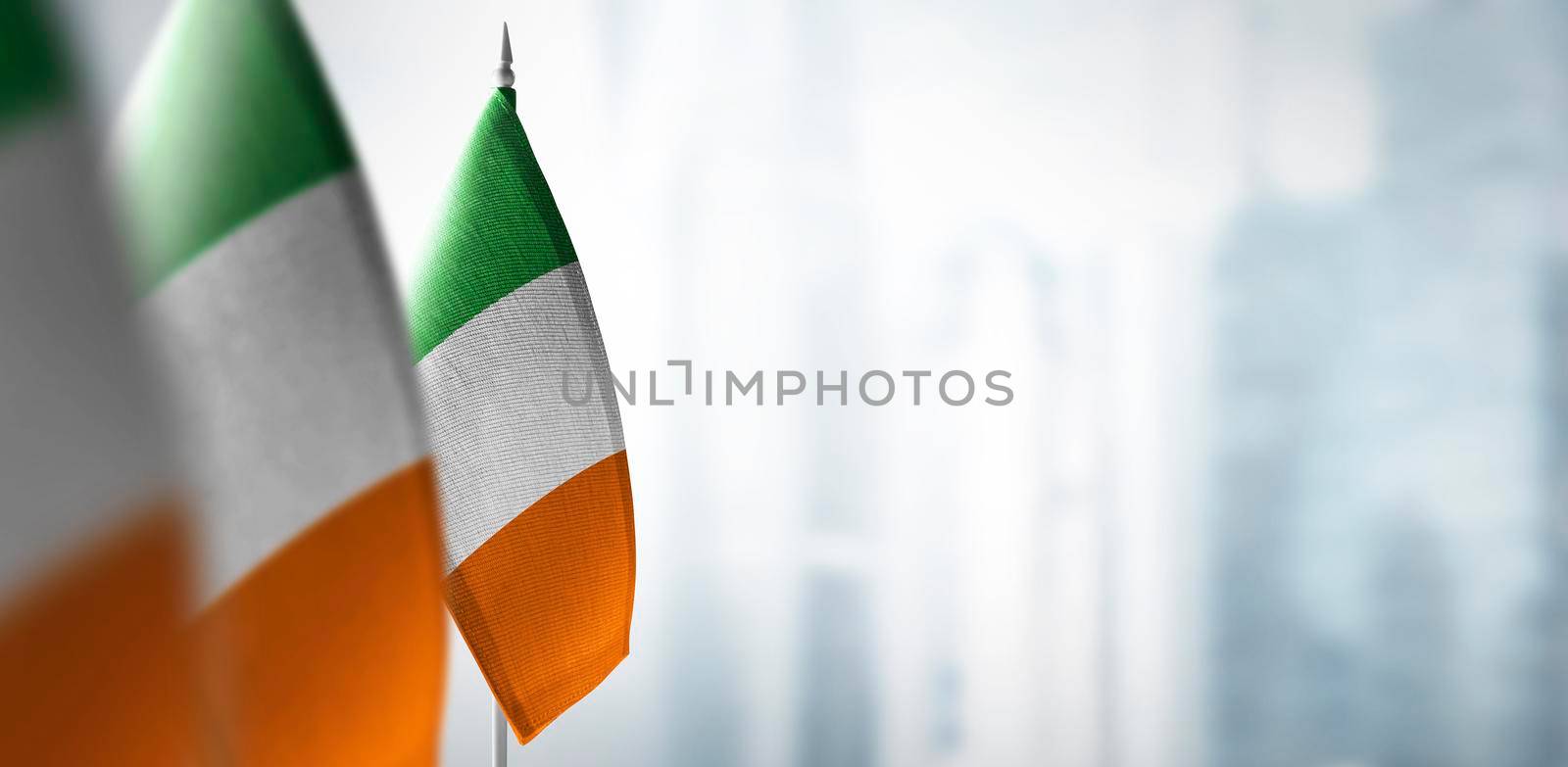 Small flags of Ireland on a blurry background of the city.