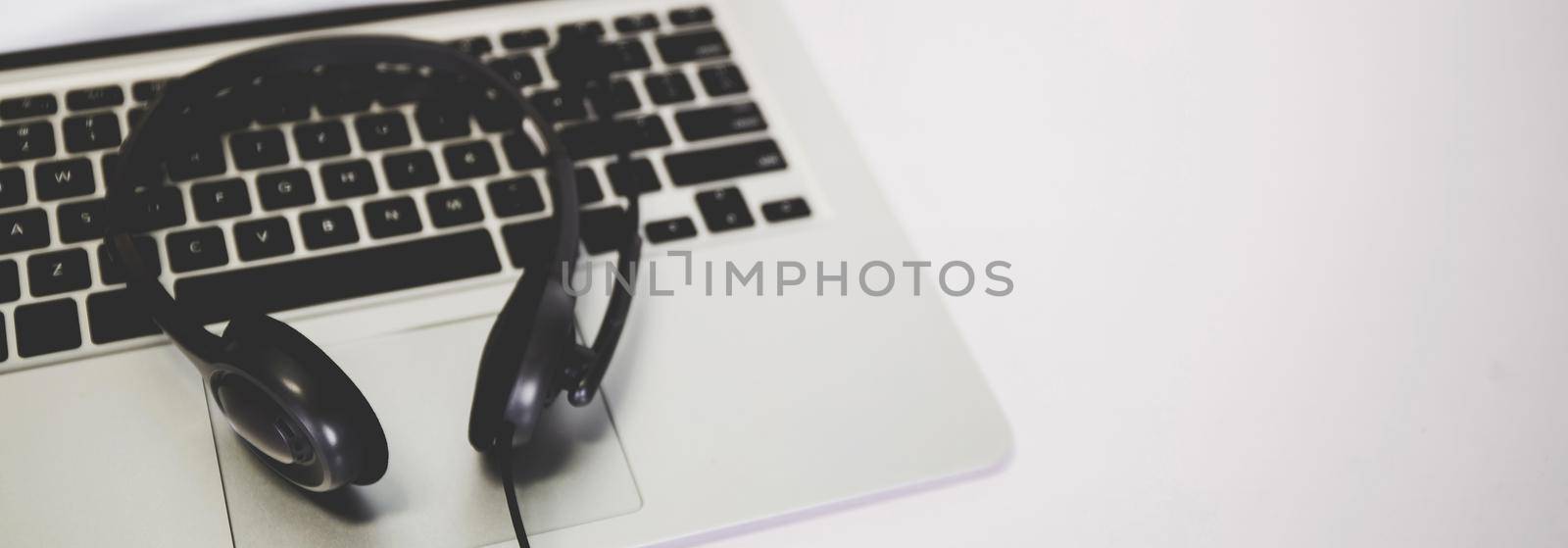 Laptop computer and headphone on desk, e-learning online, webinar for education and learning, seminar with notebook, video conference, headset for multimedia, course and classroom to internet.