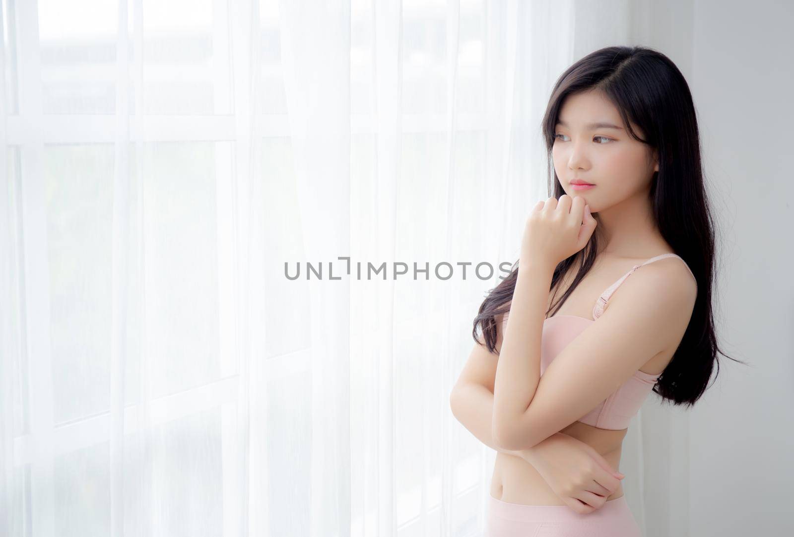 Beautiful portrait young asian woman sexy thinking idea weight loss near the windows for healthy, body of asia girl happy with diet and cheerful with wellbeing, lifestyle and relax concept. by nnudoo