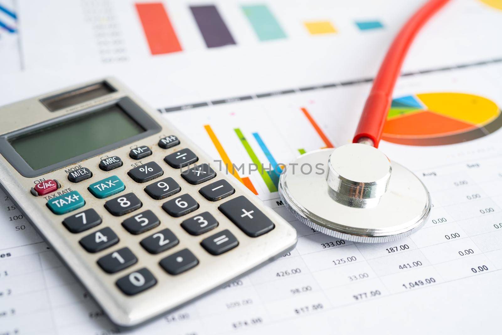 Stethoscope with calculator on chart graph paper, finance, account, statistic, analytic economy Business concept. by pamai