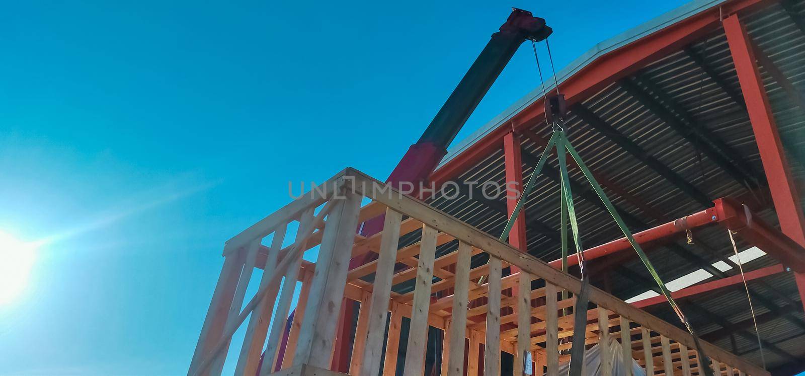 Boom truck crane lifting the machinery which storage in wooden box to stored in warehouse. Machinery transport and delivery business. Boom truck crane working at job site. Crane hoisting wooden box.