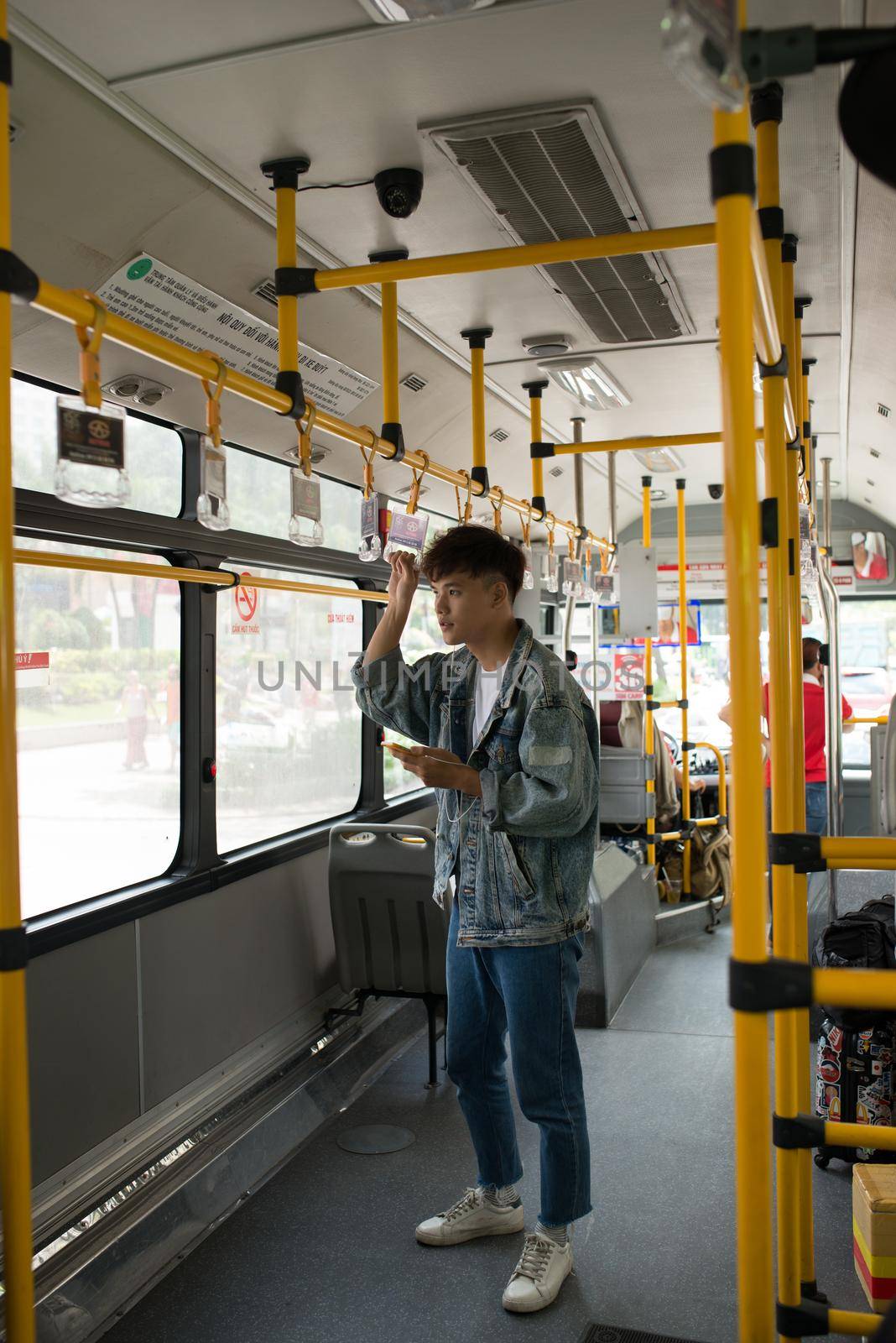 People in the bus. Asian man using smartphone in public transport