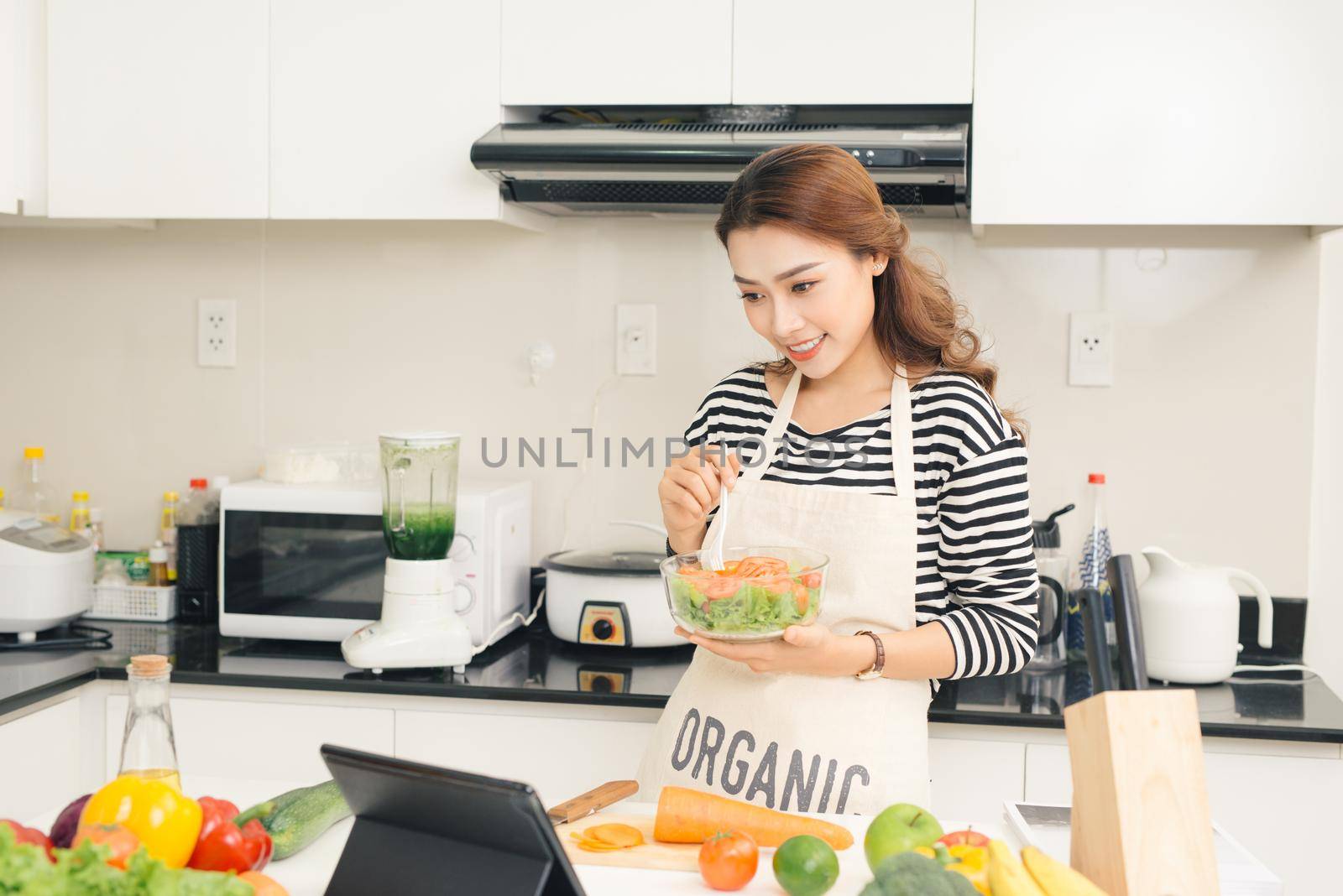 Young happy woman eating salad. Healthy lifestyle with green food. by makidotvn