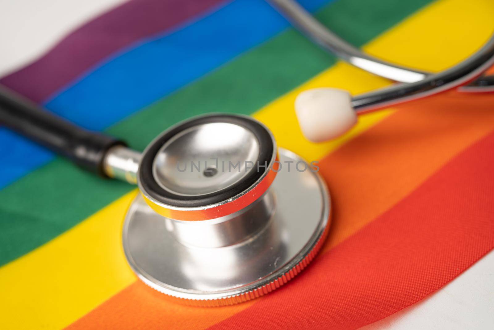 Black stethoscope on rainbow flag background, symbol of LGBT pride month celebrate annual in June social, symbol of gay, lesbian, bisexual, transgender, human rights and peace.