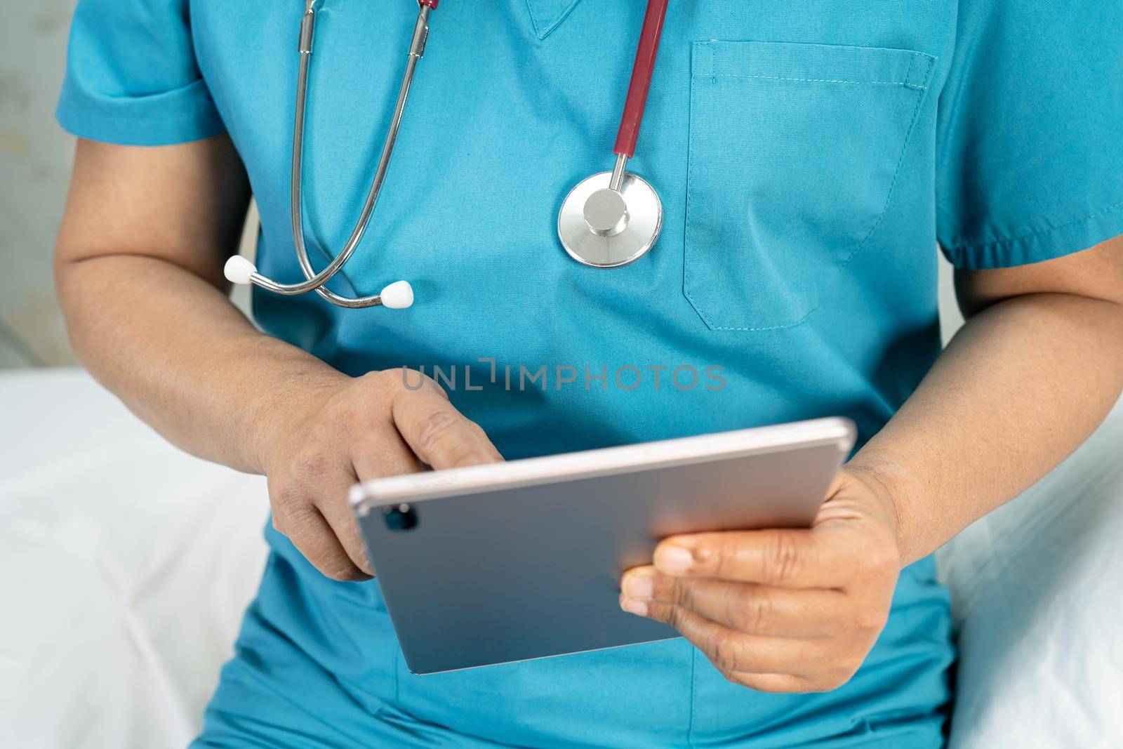 Doctor holding digital tablet to search data for treat patient in nursing hospital ward : healthy strong medical concept. by pamai