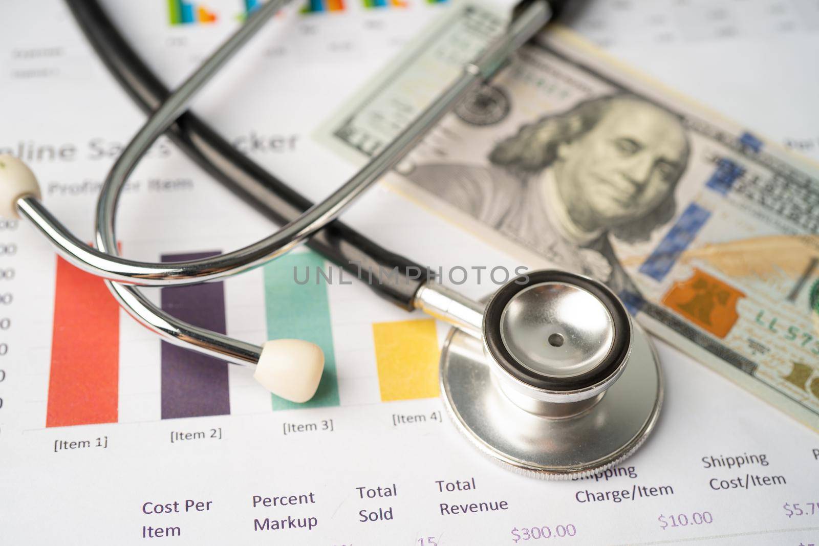 Stethoscope and US dollar banknotes on chart or graph paper, Financial, account, statistics and business data medical health concept.