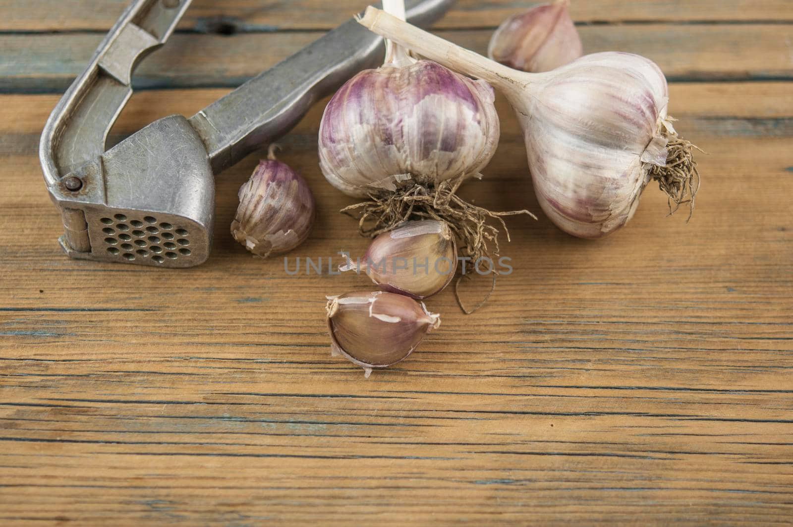 Whole garlic bulbs on a wood board by inxti