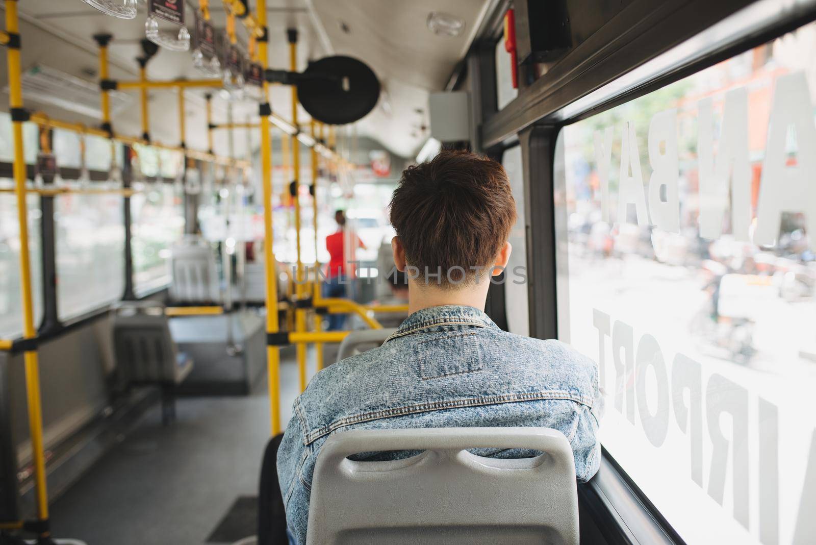 People, lifestyle, travel and public transport. Asian man standing inside city bus. by makidotvn