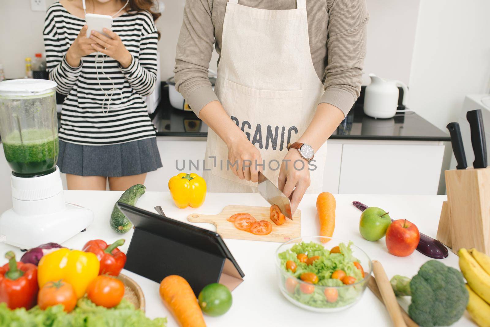 Handsome asian man chopping vegetables in the kitchen