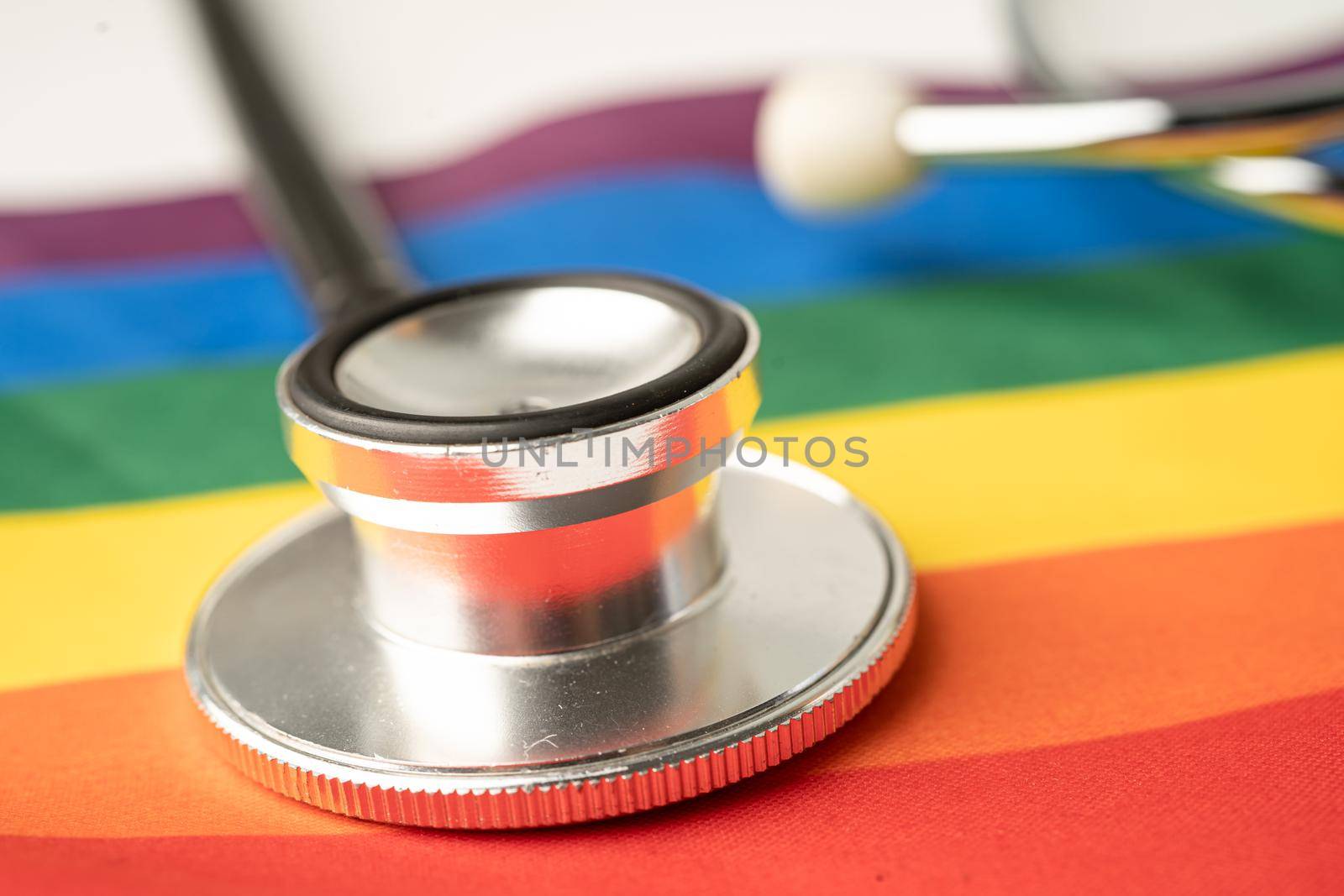 Black stethoscope on rainbow flag background, symbol of LGBT pride month celebrate annual in June social, symbol of gay, lesbian, bisexual, transgender, human rights and peace.