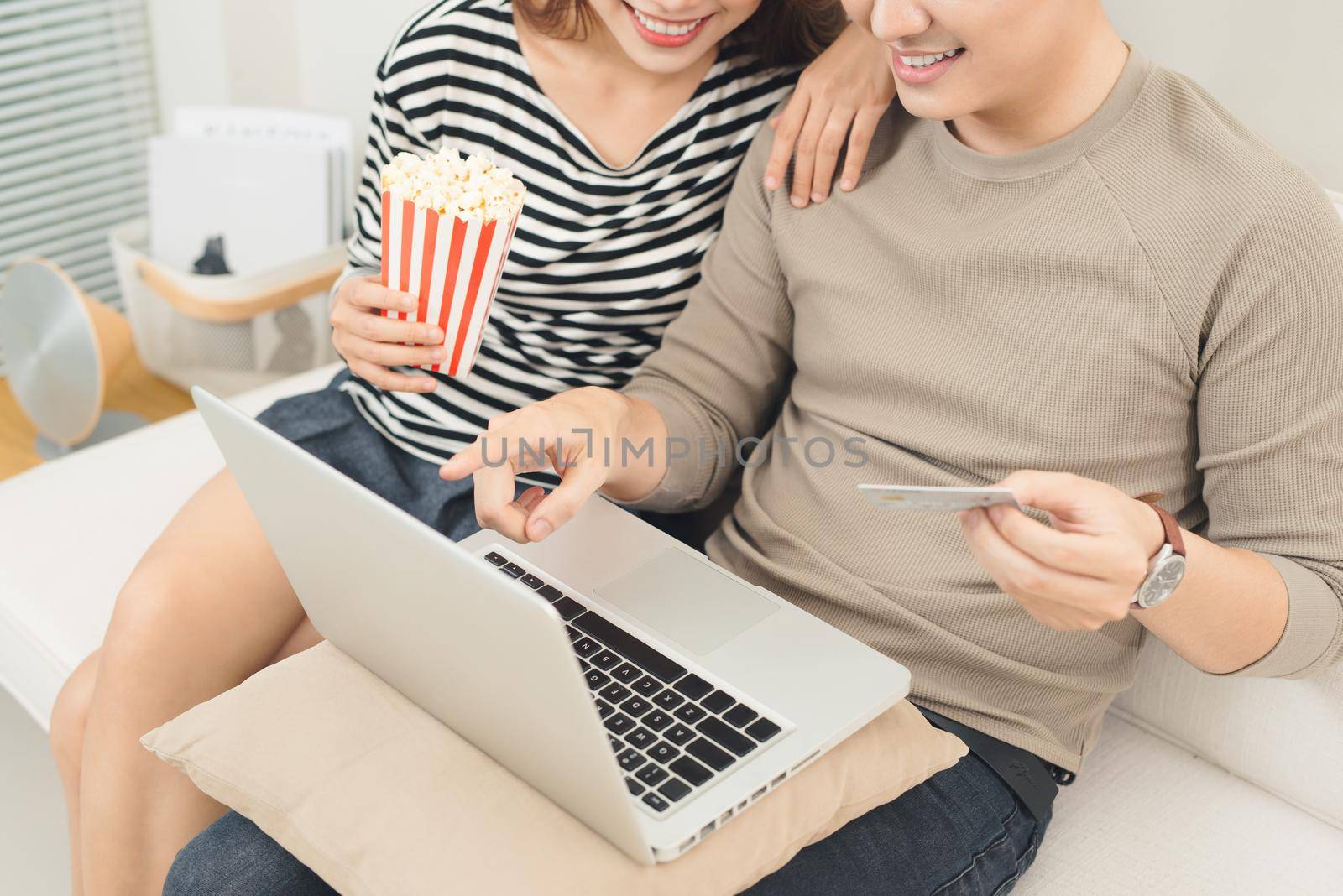 Young asian couple payment online using laptop buying movie ticket