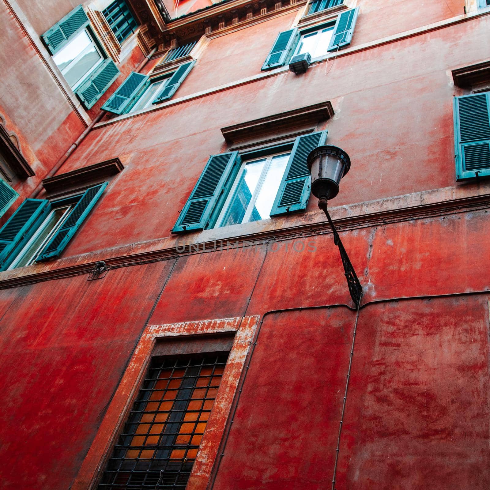 A colorful red wall of an old building in Rome, Italy