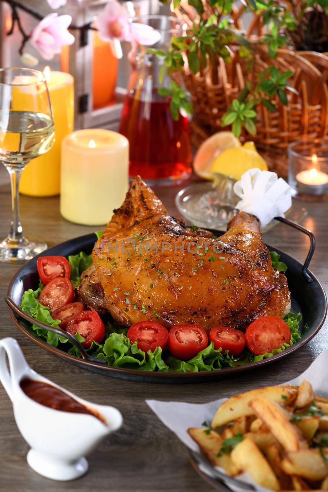 Baked turkey drumstick on a vegetable tray on a festive dinner table in honor of Thanksgiving.