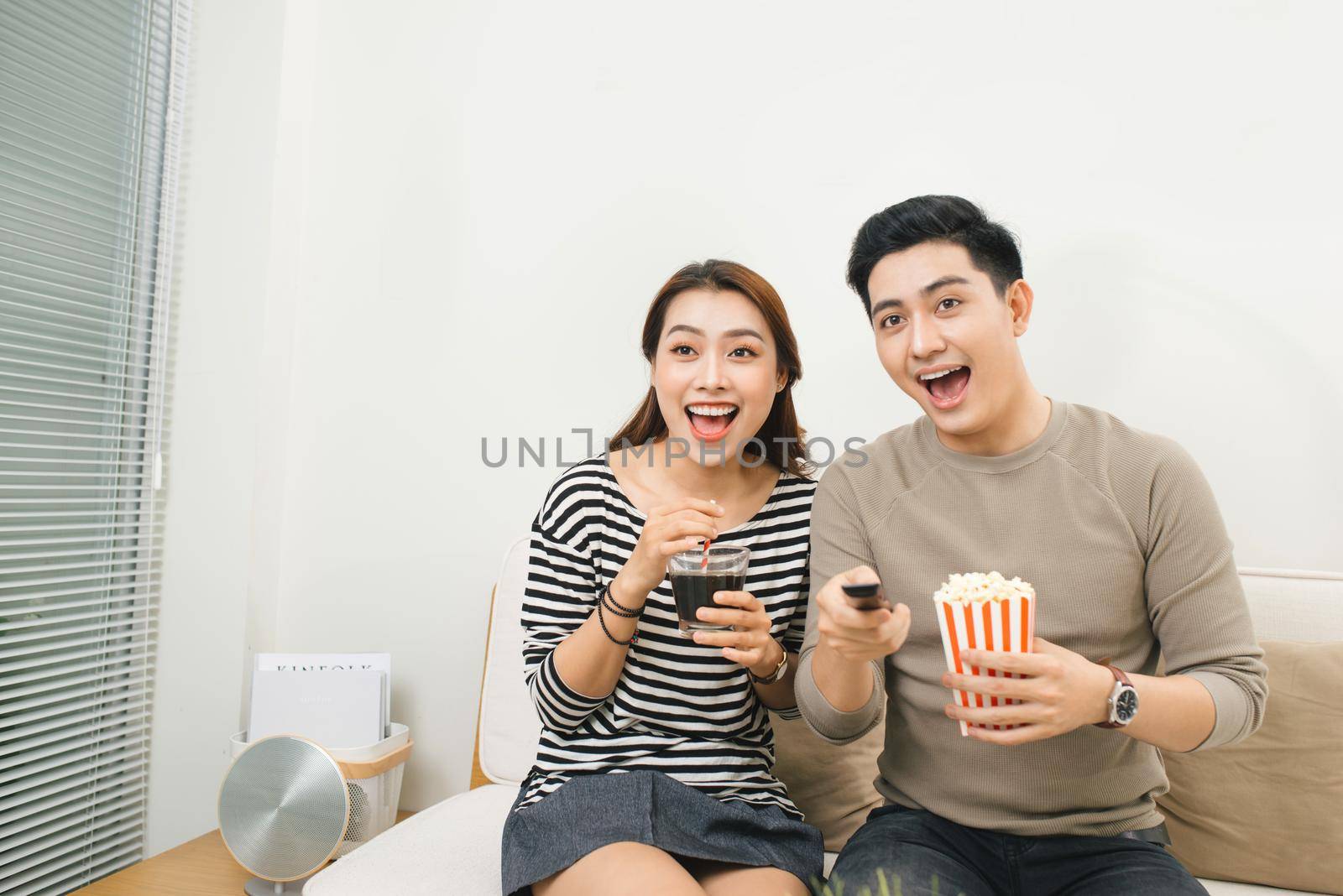 Relaxed young couple watching television in their living room by makidotvn