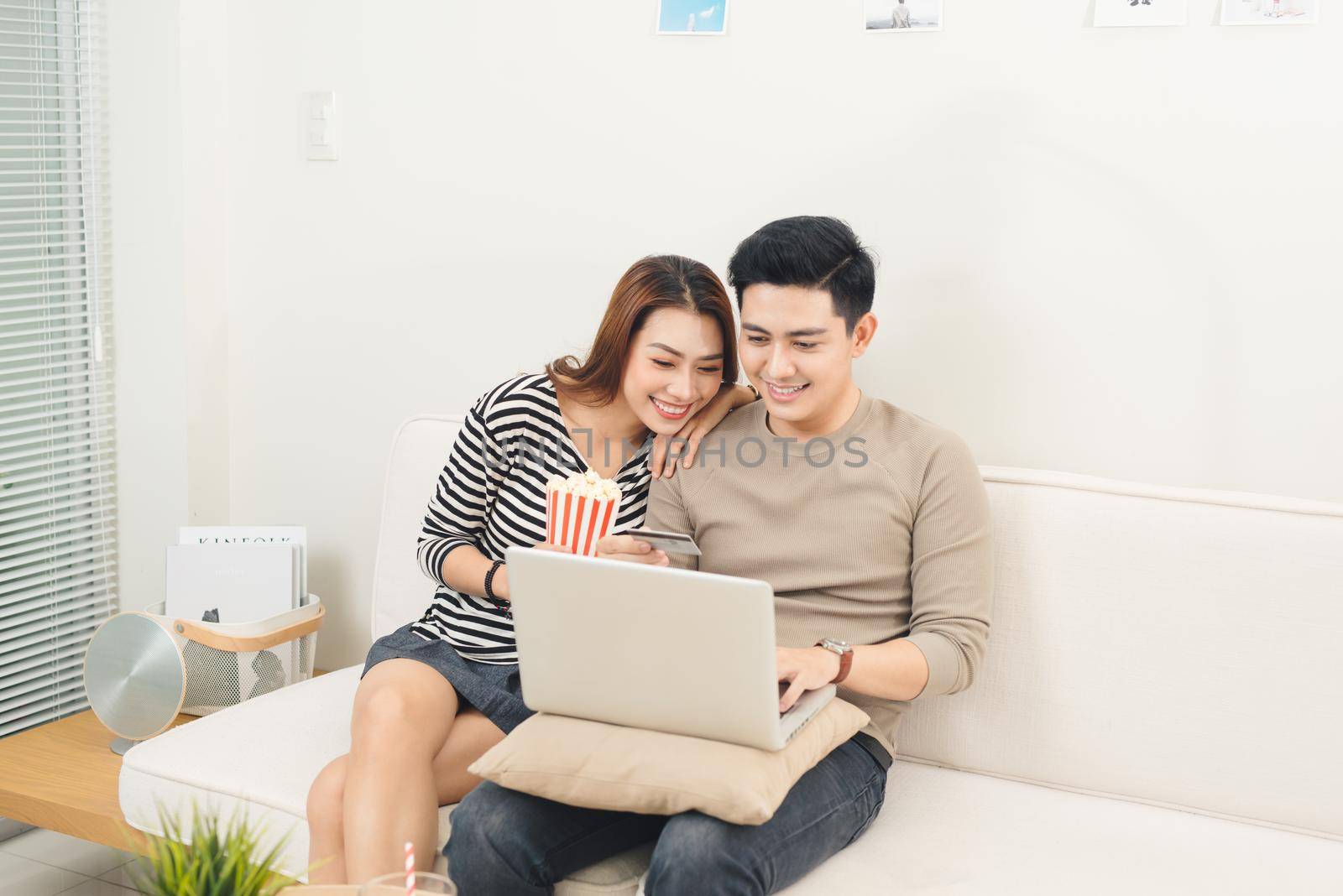 Young asian couple payment online using laptop buying movie ticket by makidotvn