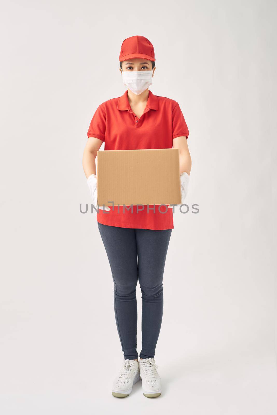 Delivery women in medical mask and rubber gloves holding cardboard boxes. by makidotvn